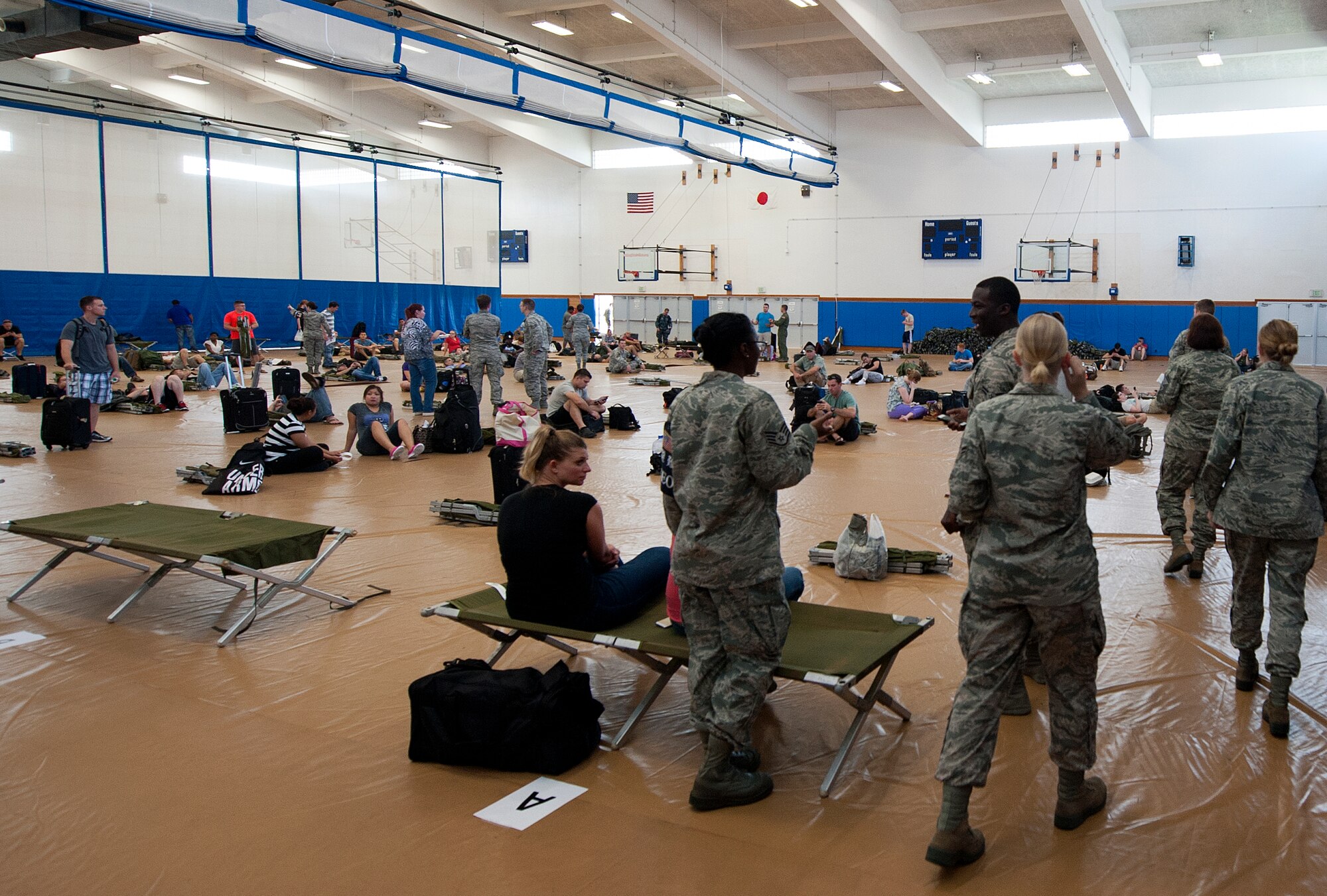 Participants and augmentees simulate a “bed-down” in the Risner Fitness Center on Kadena Air Base, Japan, Oct. 28, 2015. The focus of a NEO exercise is to gauge Kadena’s ability to receive evacuees from other points within the Indo-Asia-Pacific region as well as evacuate Kadena’s non-combatants in times of crisis. (U.S. Air Force photo by Airman 1st Class Nicholas Emerick)