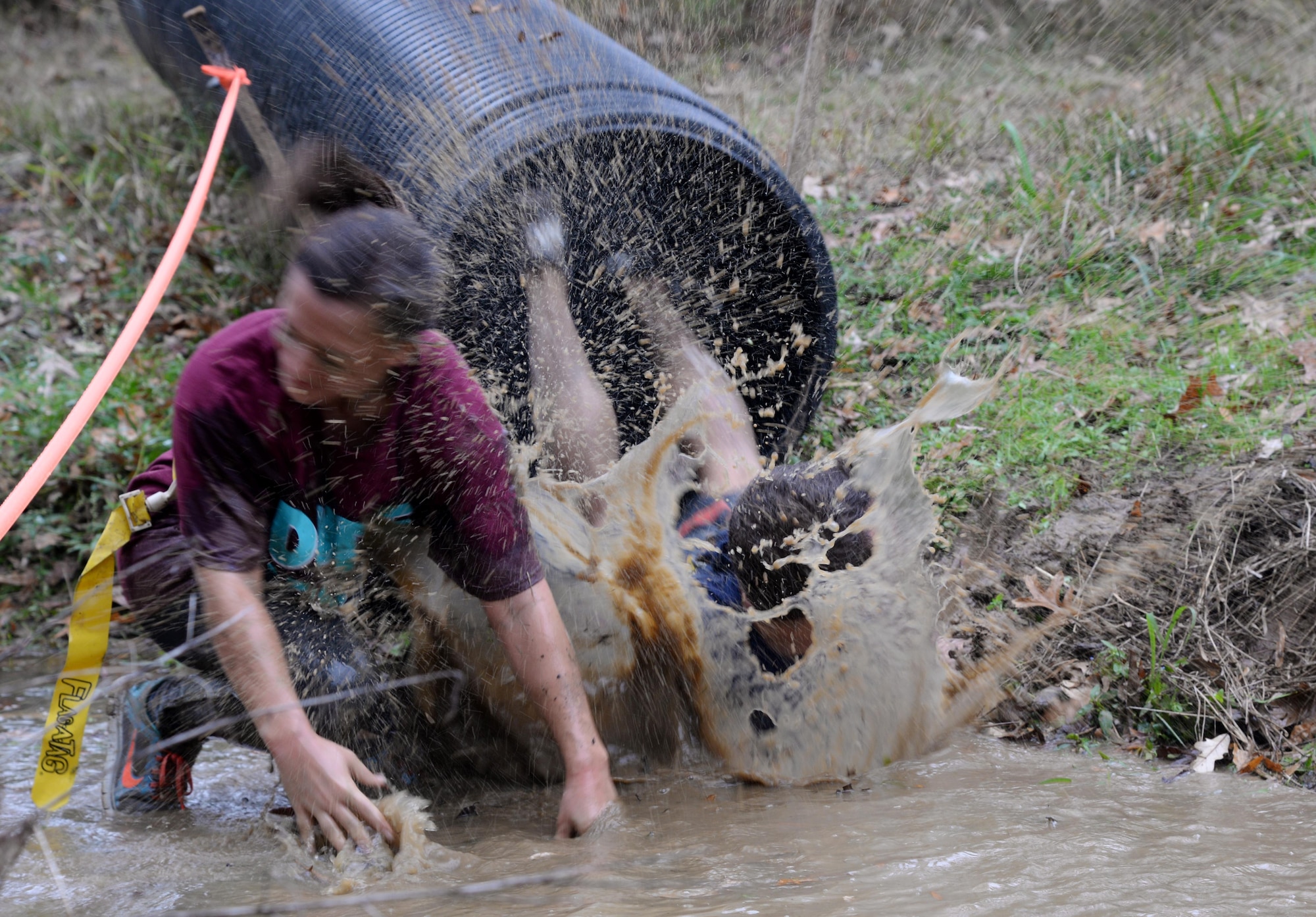 A runner dives head-first through a tube into a muddy ditch soaking other runners during the third annual Zombie Run 5k at Columbus AFB, Mississippi. The run is held in conjunction with Halloween to compliment the “spookiest” time of the year. (U.S. Air Force Photo/Airman 1st Class John Day)