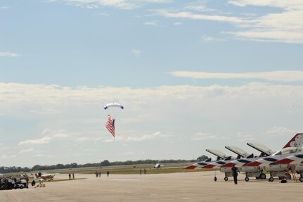 A member of the U.S. Air Force Wings of Blue carries the U.S. national flag during the 2015 Air Show and Open House at Joint Base San Antonio-Randolph Oct. 31, 2015. The Wings of Blue has both a demonstration team and a competition team. The demonstration team travels across the country to airshows, sporting events, and other venues to represent the Air Force in precision parachuting.  (U.S. Air Force photo by Melissa Peterson/released)

