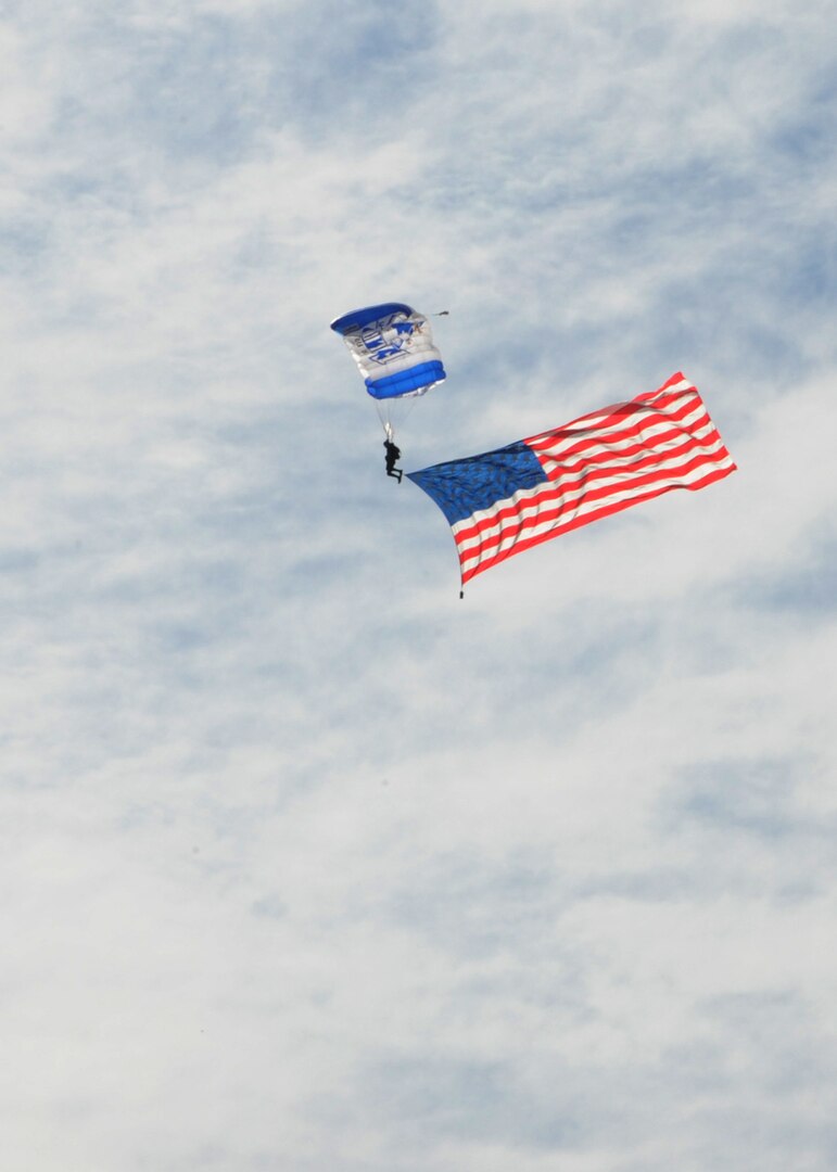 A member of the U.S. Air Force Wings of Blue prepares to land while carrying the American flag during the 2015 Air Show and Open House at Joint Base San Antonio-Randolph Oct. 31, 2015. The Wings of Blue has both a demonstration team and a competition team. The demonstration team travels across the country to airshows, sporting events, and other venues to represent the Air Force in precision parachuting.  (U.S. Air Force photo by Melissa Peterson/released)
