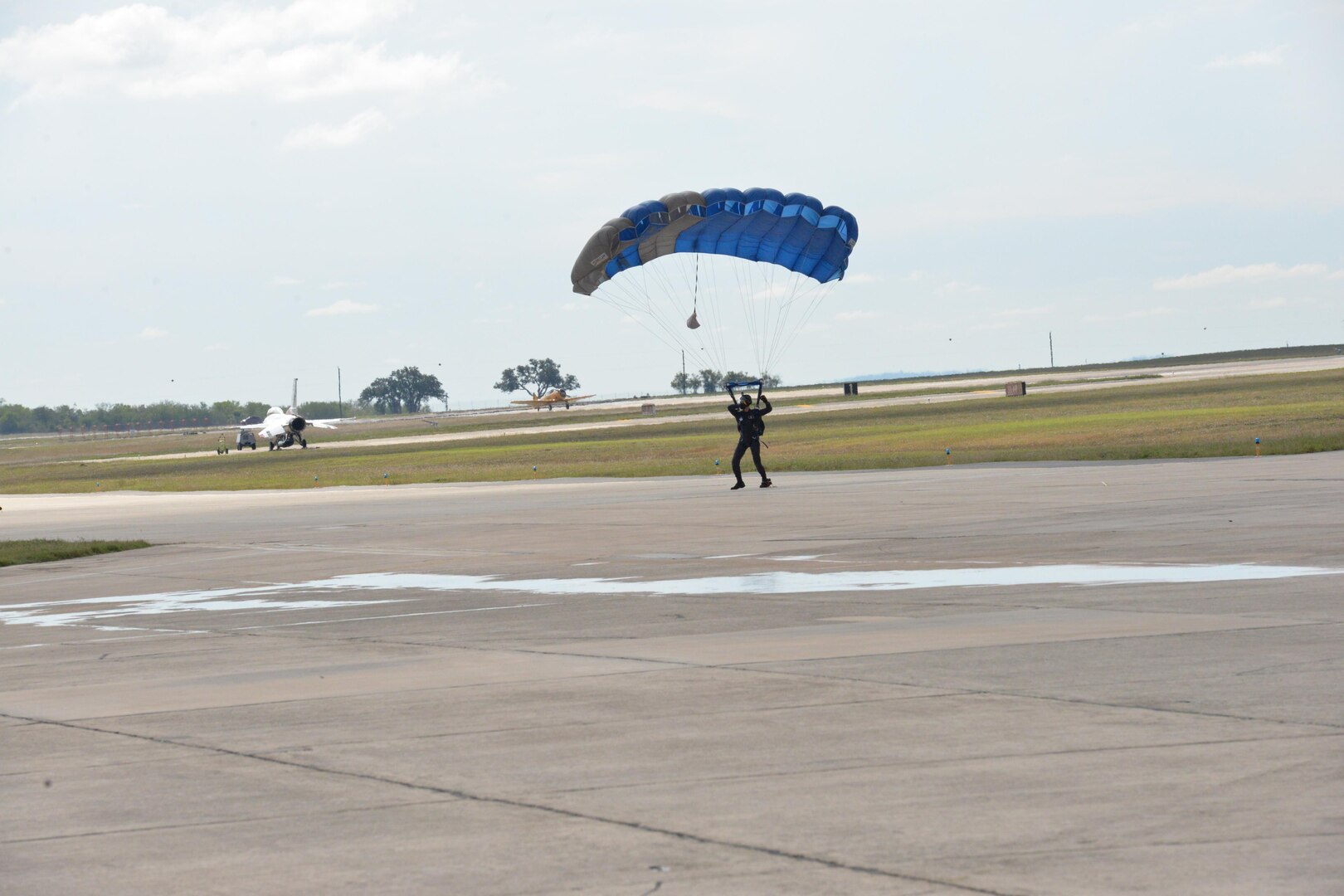 A member of the U.S. Air Force Wings of Blue parachute team lands during the 2015 Air Show and Open House at Joint Base San Antonio-Randolph Oct. 31, 2015. The Wings of Blue has both a demonstration team and a competition team. The demonstration team travels across the country to airshows, sporting events, and other venues to represent the Air Force in precision parachuting.  (U.S. Air Force photo by Olivia Mendoza/released)
