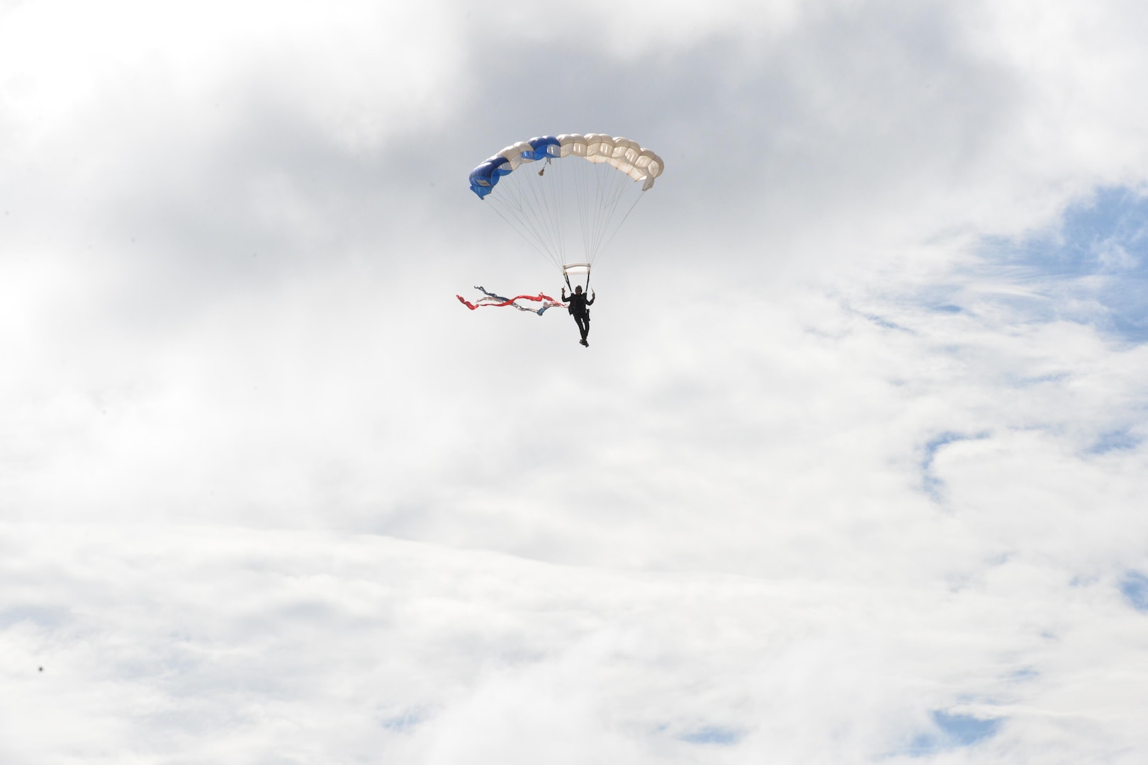 A member of the U.S. Air Force Wings of Blue parachute team performs during the 2015 Air Show and Open House at Joint Base San Antonio-Randolph Oct. 31, 2015. The Wings of Blue has both a demonstration team and a competition team. The demonstration team travels across the country to airshows, sporting events, and other venues to represent the Air Force in precision parachuting.  (U.S. Air Force photo by Olivia Mendoza/released)
