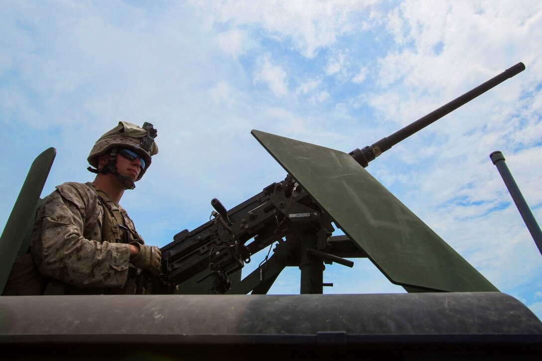 Corporal Jordan Kischel, a gunner with 3rd Low Altitude Air Defense Battalion, Marine Air Control Group 38, 3rd Marine Aircraft Wing, maintains security with an M2 .50 caliber machine gun in the turret of a Humvee tactical vehicle during a convoy air-defense exercise aboard Marine Corps Base Camp Pendleton, Calif., Aug. 25, 2015. The exercise gave the Marines the opportunity to work with a simulated enemy aircraft, an AH-1Z Cobra helicopter provided by Marine Light Attack Helicopter Squadron 169, Marine Aircraft Group 39, 3rd MAW. Realistic training allows Marines to remain effective in increasingly complex environments around the world. (U.S. Marine Corps photo by Lance Cpl. Caitlin Bevel)