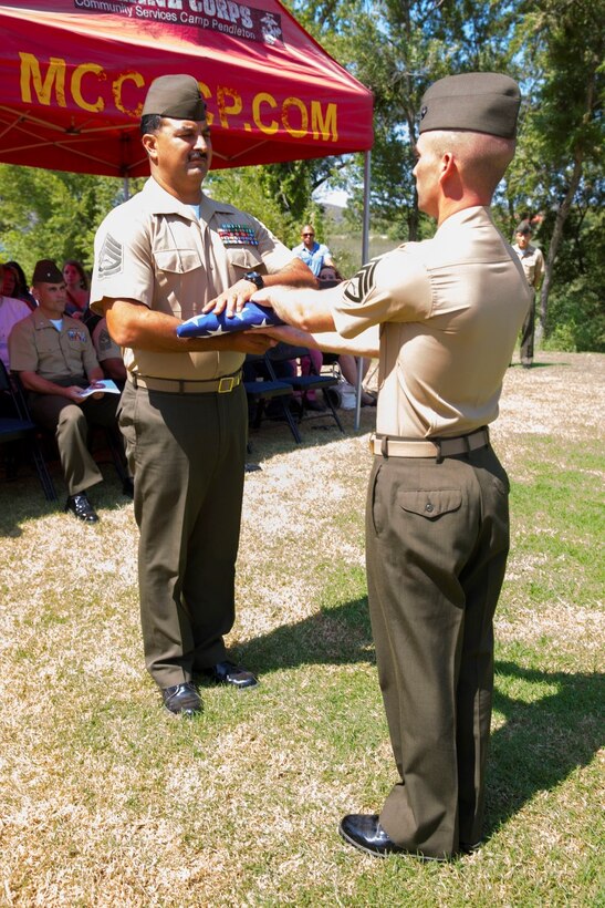 Rosamond, Calif., native, Gunnery Sgt. Pedro “Pete” Lujan, the cyber security chief for 9th Communication Battalion, I Marine Expeditionary Force Headquarters Group, receives a cased American flag during the Old Glory presentation at Lujan’s retirement ceremony aboard Marine Corps Base Camp Pendleton, Calif., Aug. 21, 2015. Lujan said he credits his success to the way the Marine Corps takes care of the Marines who serve.