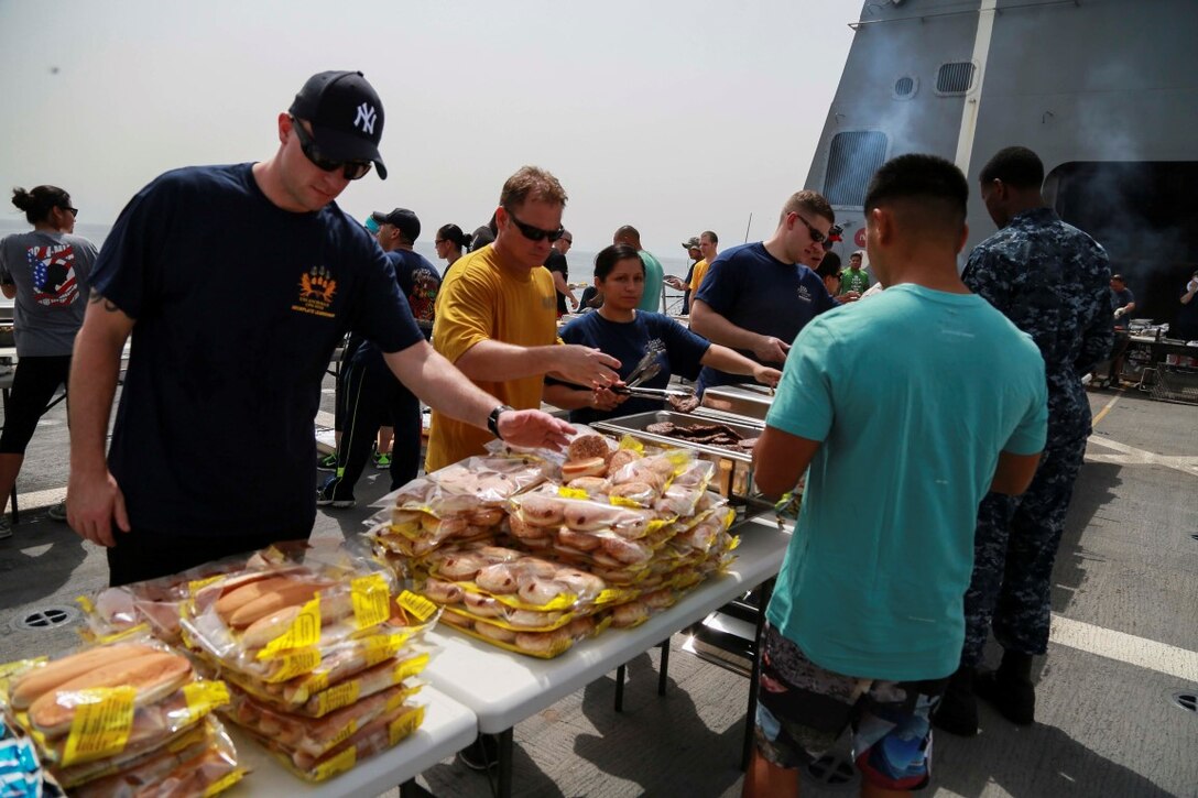 GULF OF ADEN (Aug. 29, 2015) U.S. Marines and Sailors from the 15th Marine Expeditionary Unit and Essex Amphibious Ready Group fill their plates with food at a steel beach picnic aboard the amphibious transport dock ship USS Anchorage (LPD 23). Elements of the 15th MEU are embarked aboard the Anchorage, which is part of the ESX ARG, and is deployed in support of maritime security operations and theater security cooperation efforts in the U.S. 5th Fleet area of operations. (U.S. Marine Corps photo by Sgt. Steve H. Lopez/Released)