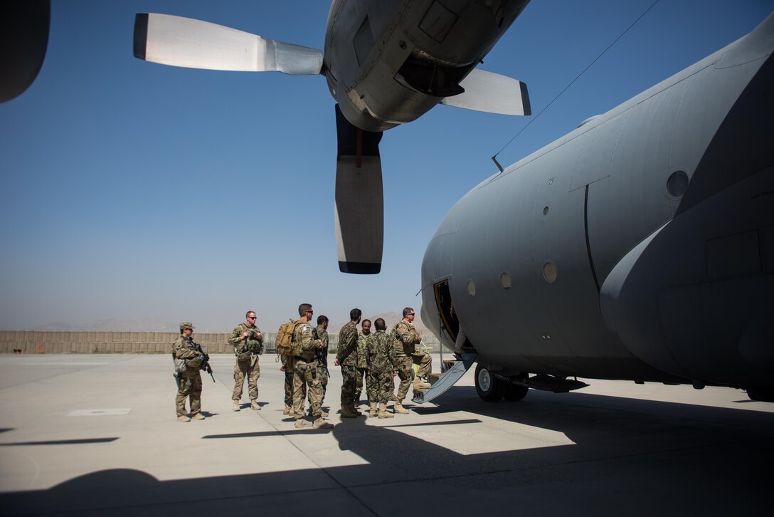 U.S. Air Force Master Sgt. Michael Doane, Train Advice Assist Command-Air flight equipment advisor and operations team superintendent, Airmen assigned to the 455th Air Expeditionary Wing and Afghan airman enter an Afghan C-130H Hercules aircraft to train on aircrew flight equipment, at Hamid Karzai International Airport, Kabul, Afghanistan, Aug. 29, 2015. Airmen with the 455th AEW visited Forward Operating Base Oqab and Hamid Karzai International Airport to share their aircrew flight equipment knowledge with their Afghan counterparts and also assist TAAC-Air with keeping Coalition AFE equipment current. (U.S. Air Force photo by Tech. Sgt. Joseph Swafford/Released)