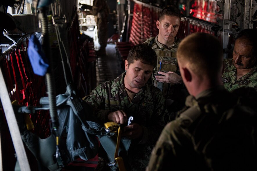 An Afghan airman demonstrates his aircrew flight equipment knowledge to U.S. Airmen from the 455th Air Expeditionary Wing and Train, Advice, Assist Command-Air aboard an Afghanistan air force C-130H Hercules at Hamid Karzai International Airport, Afghanistan, Aug. 29, 2015. Airmen with the 455th AEW visited Forward Operating Base Oqab and Hamid Karzai International Airport to share their AFE knowledge with their Afghan counterparts and also assist TAAC-Air with keeping coalition AFE equipment current. (U.S. Air Force photo/Tech. Sgt. Joseph Swafford)