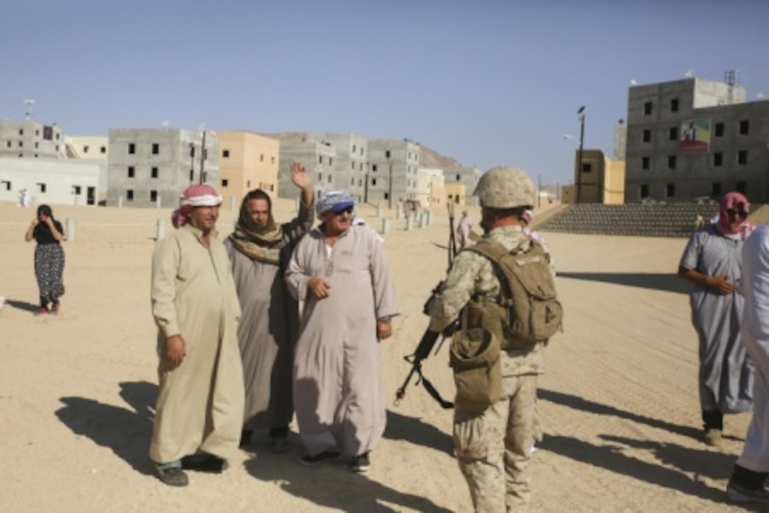 Lance Cpl. Austin David, a Marine with Combat Logistics Battalion 1, Combat Logistics Regiment 1, communicates with role-players in order to receive information about enemy movement in the area during Large Scale Exercise 15 aboard Marine Corps Air Ground Combat Center Twentynine Palms, Calif., Aug. 18, 2015. LSE-15 is a combined U.S. Marine Corps, Canadian and British exercise conducted at the brigade level, designed to enable live, virtual and constructive training for participating forces. (U.S. Marine Corps photo by Lance Cpl. Chris Garcia/Released)
