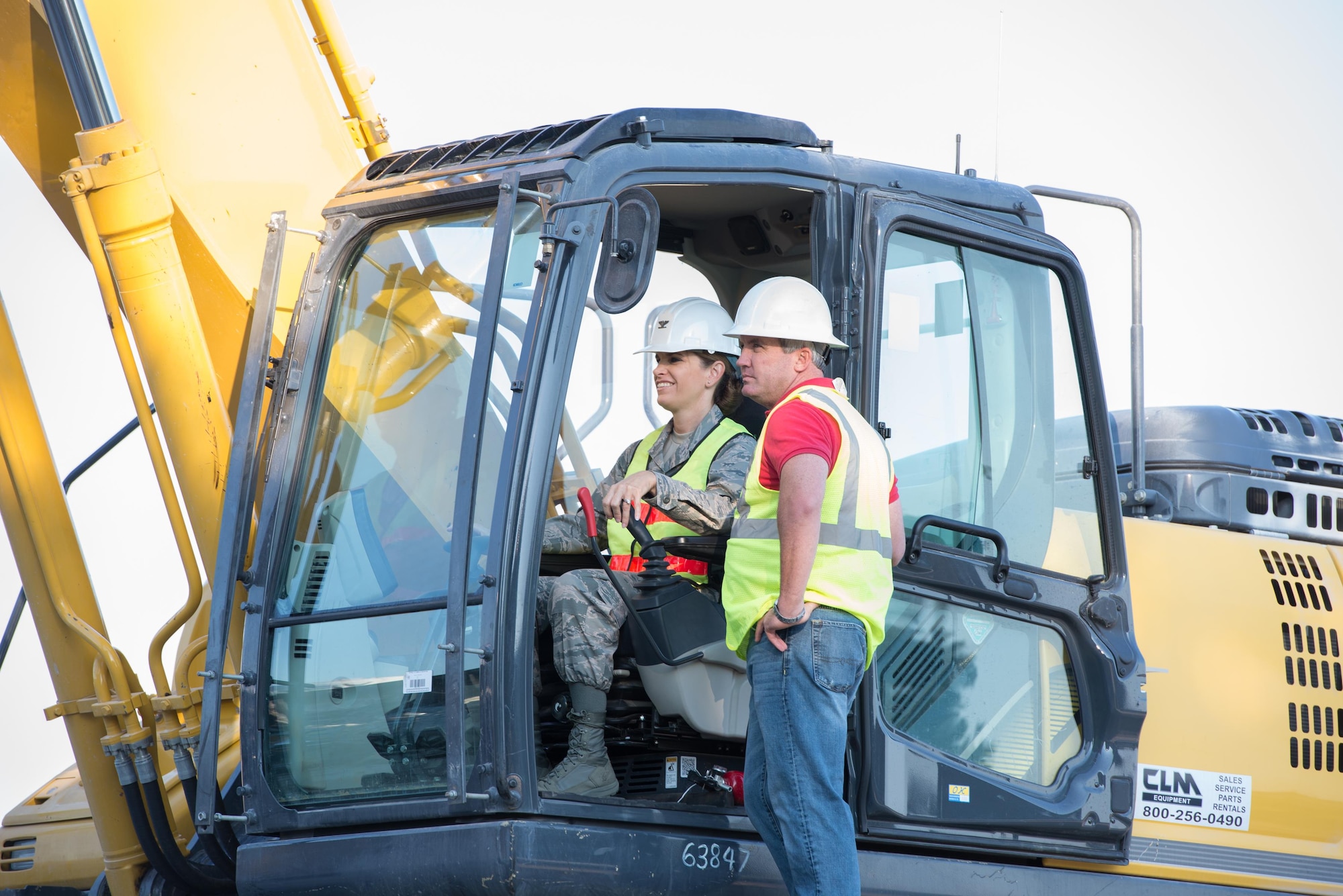 Col. Michele Edmondson, 81st Training Wing commander, receives instructions from Jamie Bean, base operations support contractor, as she operates an excavator to continue the demolition of Hewes Hall, August 28, 2015, at Keesler Air Force Base, Miss. In addition to helping the Air Force plan to reduce its footprint by 20% before 2020, the building was also demolished because it was within the clear zone of the air field. (U.S. Air Force photo by Marie Floyd)