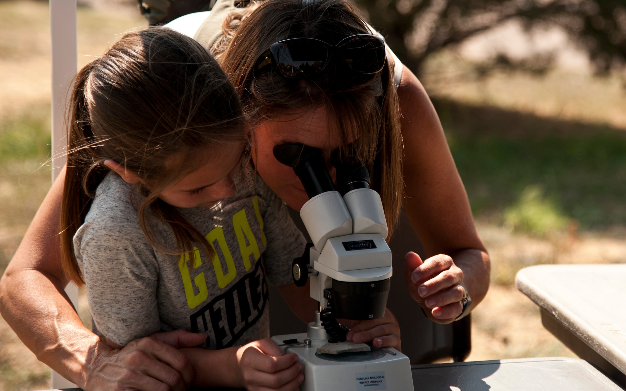 PETERSON AIR FORCE BASE, Colo. – Debbie Burchfield and her daughter, Kelly, look at small fossils through a microscope during the Science, Technology, Engineering, and Math event at the Peterson Air and Space Museum, Aug. 29, 2015. The National Park Service’s fossil demonstration was one of many military and local groups that came together for the free annual event to promote STEM to military families. (U.S. Air Force photo by Senior Airman Tiffany DeNault)