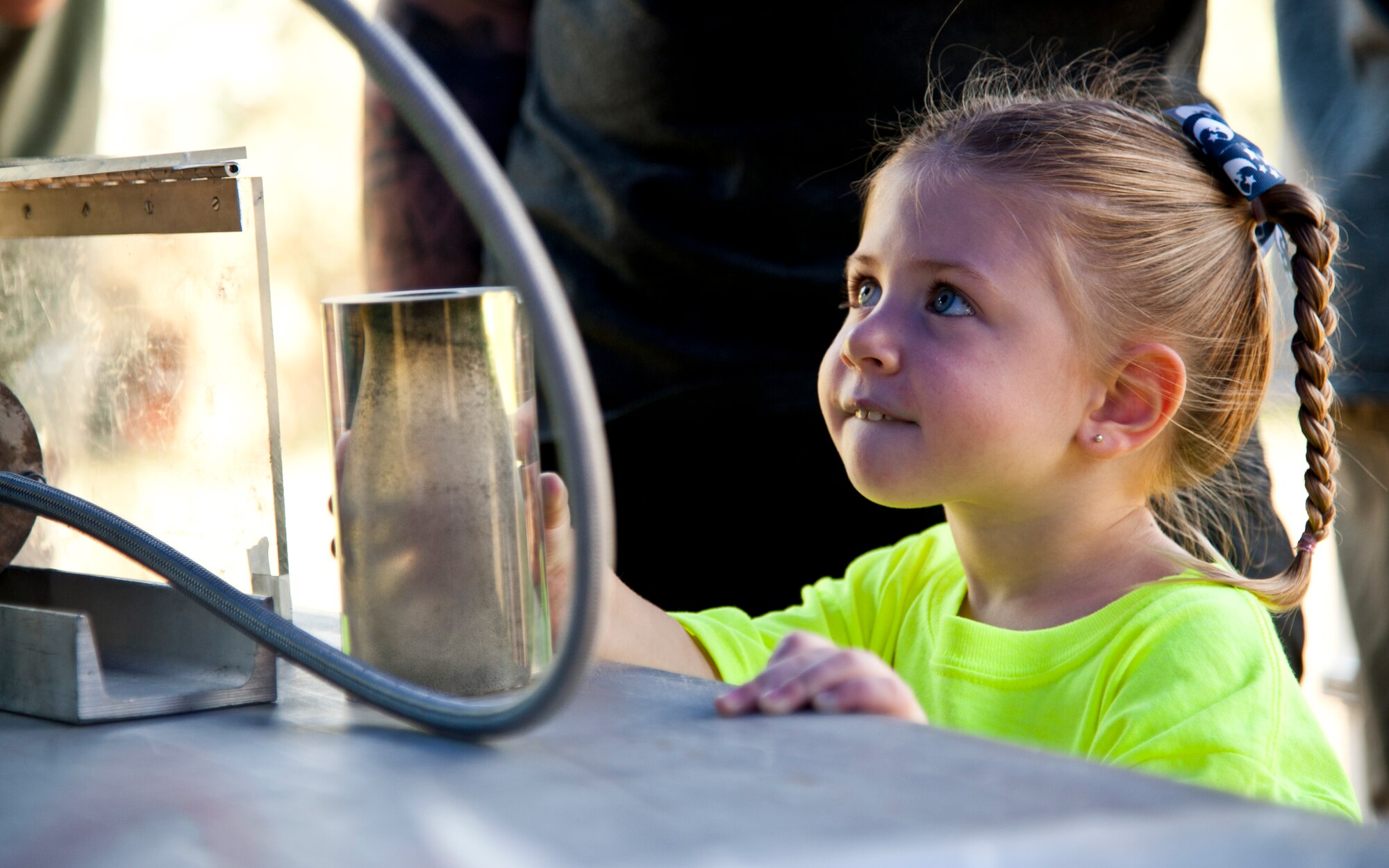 PETERSON AIR FORCE BASE, Colo. – Imogen O’Donley looks at a jet fuel simulator demonstrated by U.S. Air Force Academy cadets during the Science, Technology, Engineering, and Math event at the Peterson Air and Space Museum, Aug. 29, 2015. The jet fuel simulator was one of many booths at the free annual event including food, mining for minerals, rocket building/launching and more. (U.S. Air Force photo by Senior Airman Tiffany DeNault)