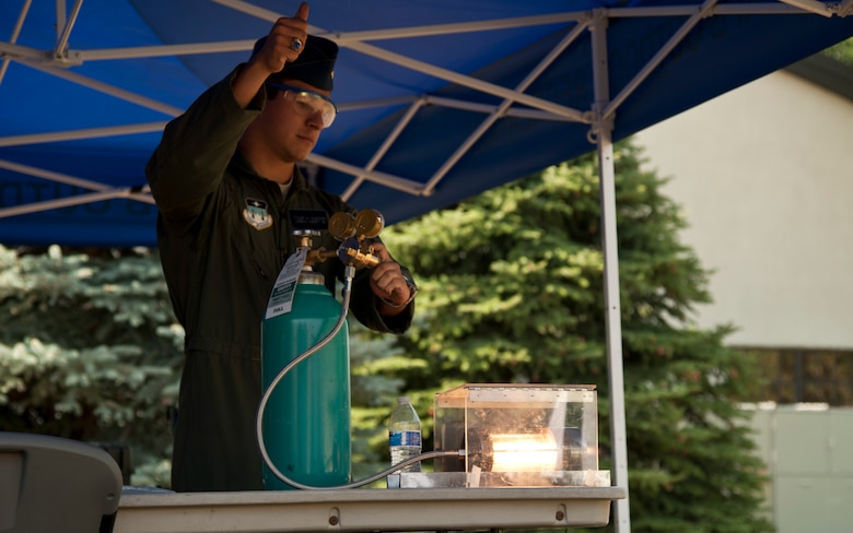 PETERSON AIR FORCE BASE, Colo. – Cadet Tyler Hudson, U.S. Air Force Academy, demonstrates how jet fuel works during the Science, Technology, Engineering, and Math event at the Peterson Air and Space Museum, Aug. 29, 2015. Volunteers from Peterson AFB and other surrounding bases came together to make the annual event a success promoting STEM topics through booths demonstrating electricity, mineral mining, rocket launching, dinosaurs and more. (U.S. Air Force photo by Senior Airman Tiffany DeNault)