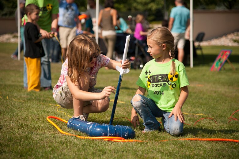 PETERSON AIR FORCE BASE, Colo. – Torrie Sheard and Aurora Mayo prepare their custom designed rocket for launch during the Science, Technology, Engineering, and Math event at the Peterson Air and Space Museum, Aug. 29, 2015. Rocket building/launching was one of many activities present at the annual event promoting STEM topics to military children. (U.S. Air Force photo by Senior Airman Tiffany DeNault)