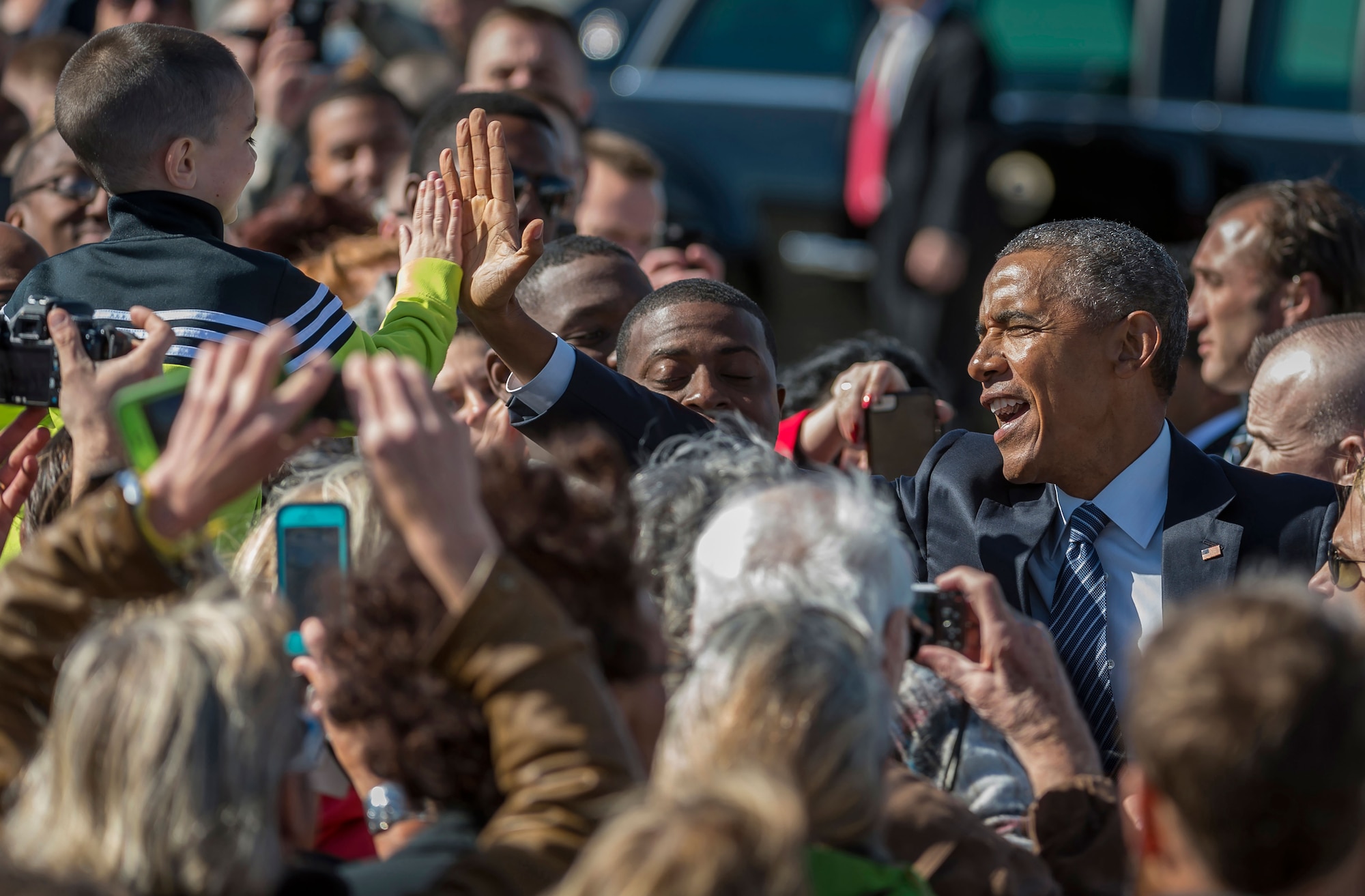 President Barack Obama gives a high-five to a child in the crowd after disembarking from Air Force One at Joint Base Elmendorf-Richardson, Alaska, Monday, Aug. 31, 2015. President Obama was the main speaker at a major event yesterday in Anchorage, Alaska, hosted by the U.S. Department of State entitled the Conference on Global Leadership in the Arctic: Cooperation, Innovation, Engagement and Resilience (GLACIER). GLACIER will focus the world’s attention on the most urgent issues facing the Arctic today and provide an unprecedented opportunity for foreign ministers and key stakeholders to define the region’s most crucial challenges; highlight innovative ways in which these challenges can be addressed at the local, national and international levels; and broaden global awareness of the impacts of Arctic climate change.  (U.S. Air Force photo/Justin Connaher)