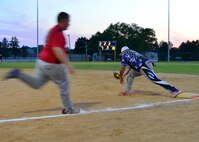 Rafael Gonzalez, 436th Security Forces Squadron first baseman, scoops a throw while Darren Kopera runs towards first base during an intramural softball game Aug. 14, 2015, at the softball field on Dover Air Force Base, Del. A one game tie breaker was played to see who would clinch the fourth playoff spot in the American League; 436th SFS won the game 20-7. (U.S. Air Force photo/Airman 1st Class William Johnson)