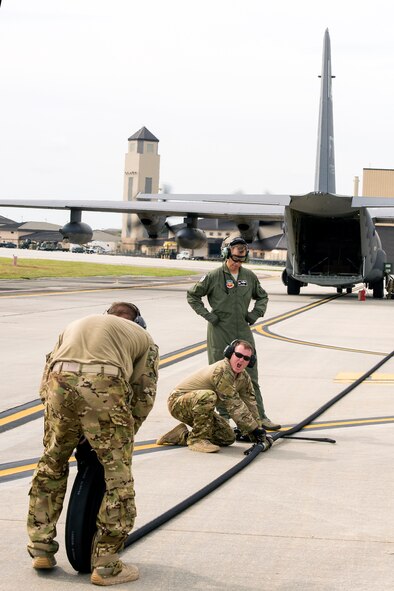U.S. Air Force Col. Thomas Dorl, 347th Rescue Group commander, watches as Senior Airman Adam Fleming, 23d Logistics Readiness Squadron fuels distribution supervisor, and Staff Sgt. Tyler Pillmore, 23d LRS Forward Area Refueling Point team chief, rolls up a fuel line hose during FARP training Aug. 28, 2015, at Moody Air Force Base, Ga.  The 23d LRS Fuels Management Flight fueled four A-10C Thunderbolt IIs, which each averaged six minutes completion time during the FARP training. (U.S. Air Force photo by Airman 1st Class Greg Nash/Released)