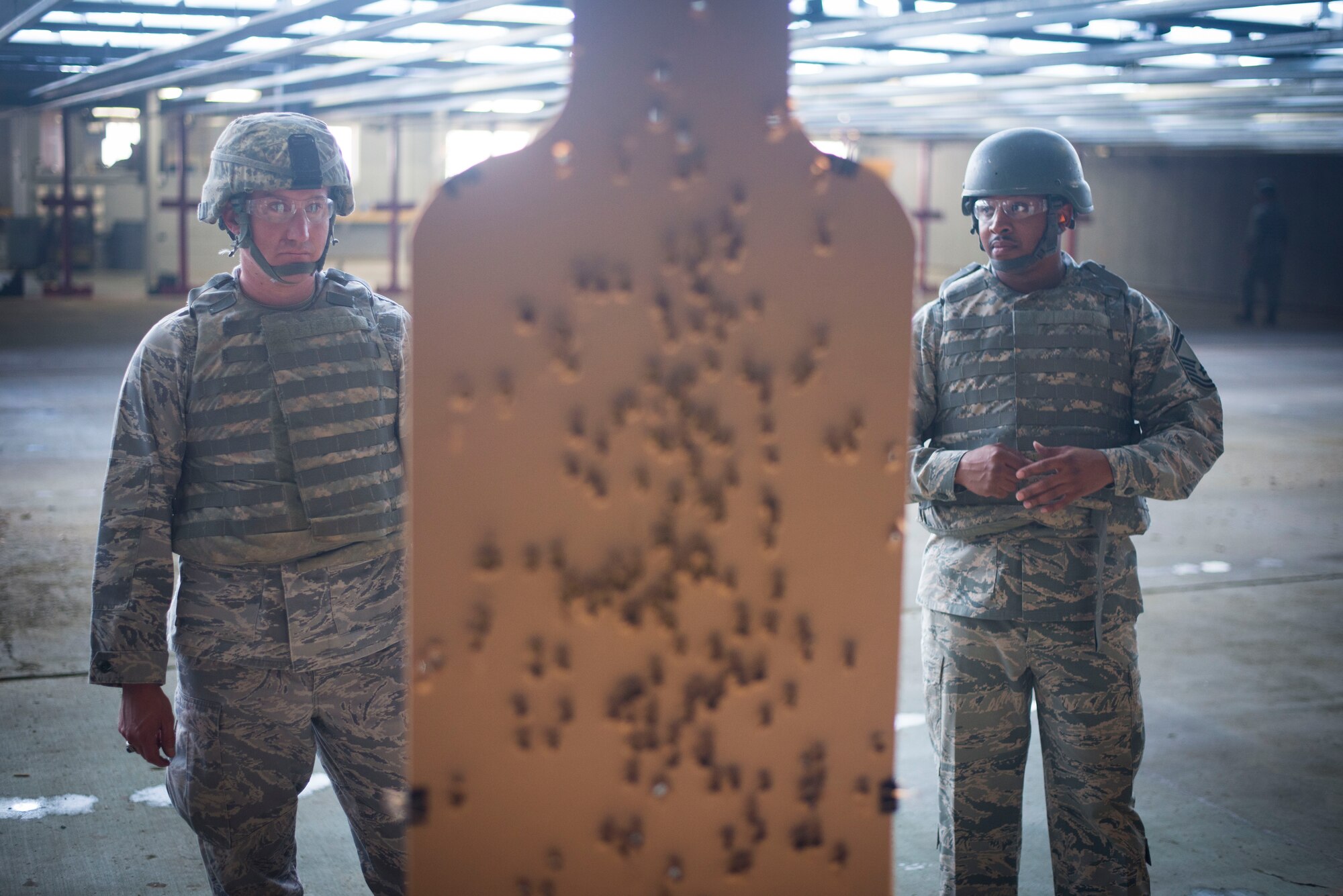 Airmen inspect their targets after firing during weapons training on Joint Base Andrews, Md., Sept. 1, 2015. Airmen attend weapons training on a routine basis to maintain readiness standards. (U.S. Air Force photo by Staff Sgt. Chad C. Strohmeyer/Released)