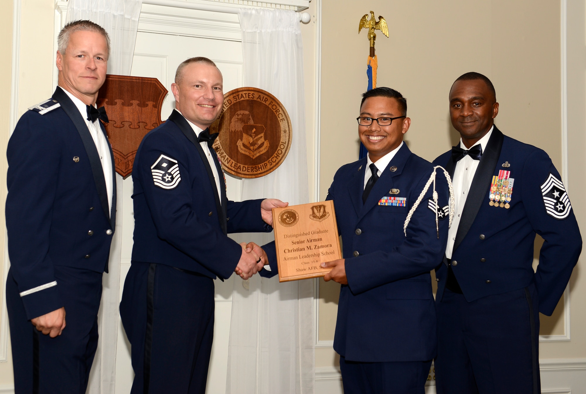 U.S. Air Force Senior Airman Christian Zamora, 51st Intelligence Squadron (right), receives a distinguished graduate award for Class 15-6 of the Senior Master Sgt. David B. Reid Airman Leadership School from Master Sgt. Gregory Spiczka, 20th Security Forces Squadron first sergeant, and 20th Fighter Wing leadership , at Shaw Air Force Base, S.C., Aug. 27, 2015. The distinguished graduate awards are given to the top 10 percent of the class for total point accumulation. (U.S. Air Force photo by Airman 1st Class Christopher Maldonado/Released)