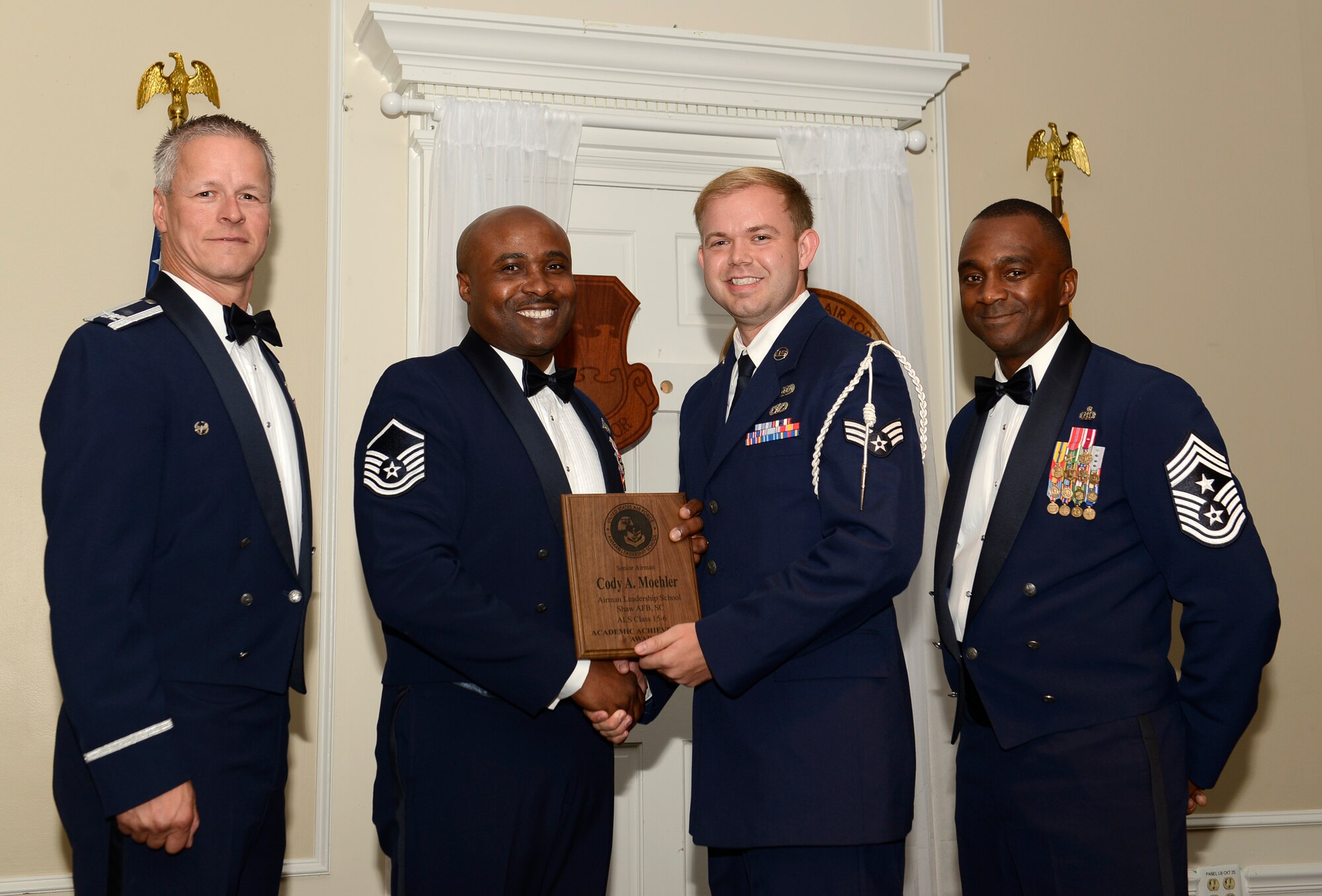 U.S. Air Force Senior Airman Cody Moehler, 20th  Civil Engineer Squadron (right), receives the academic achievement award from Master Sgt. Christopher Cohen, 20th Force Support Squadron Honor Guard Superintendent, and 20th Fighter Wing leadership at the Senior Master Sgt. David B. Reid Airman Leadership School class 15-6  graduation at Shaw Air Force Base, S.C., Aug. 27, 2015. This award is given to the student with the highest point total. (U.S. Air Force photo by Airman 1st Class Christopher Maldonado/Released)