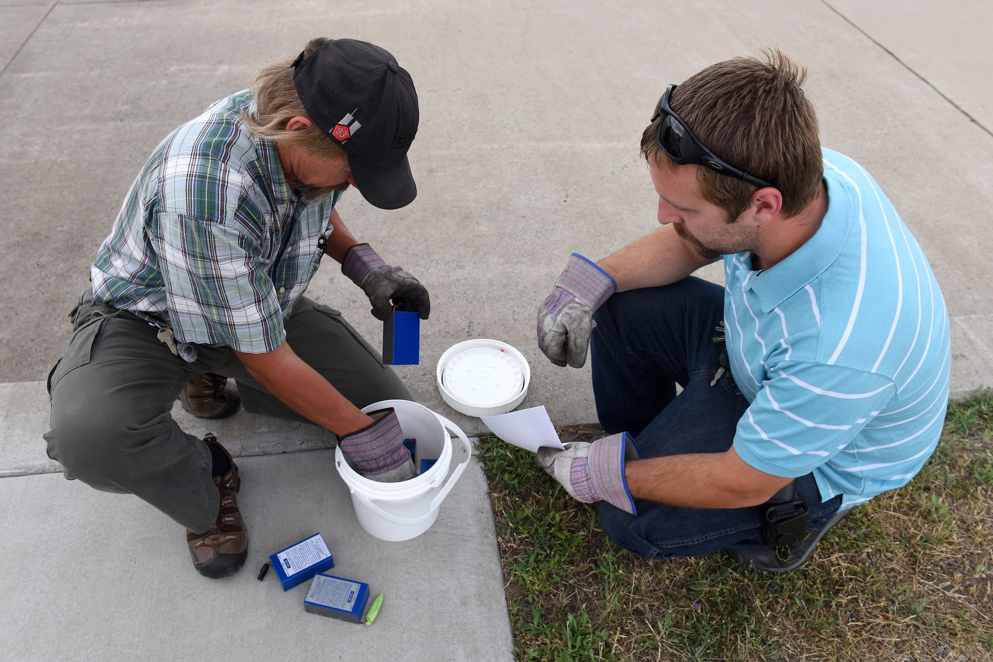 Elwood Skipper, left, and Jeffrey Goodrich, 341st Civil Engineer Squadron environmental technicians, store universal waste batteries in a 90-day storage drum Aug. 18, 2015, at Malmstrom Air Force Base, Mont. The shop disposes of approximately 26,000 pounds of hazardous waste each year. (U.S. Air Force photo/Chris Willis)