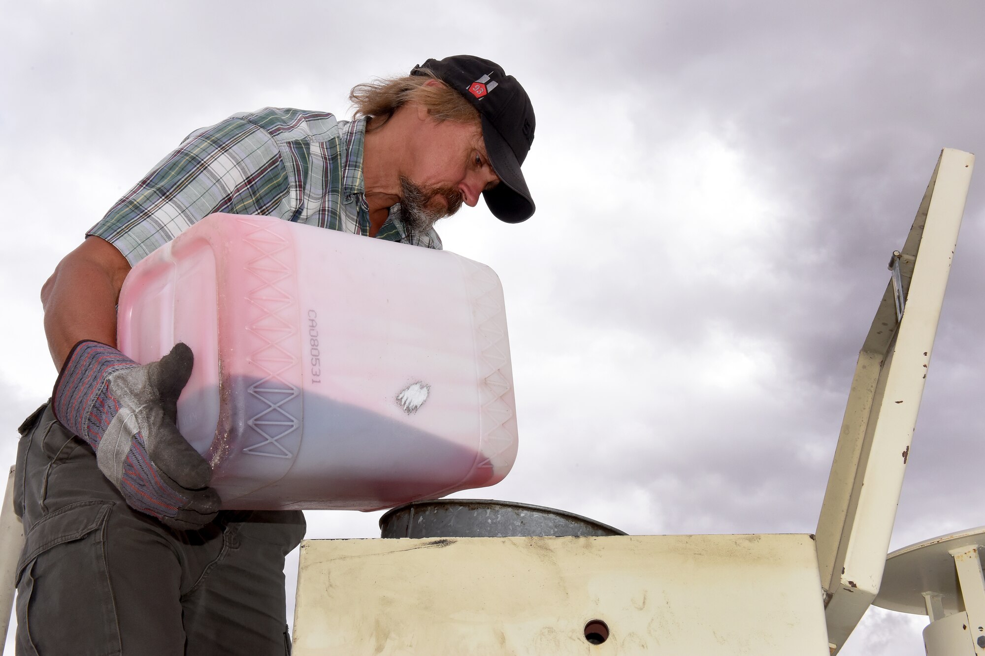 Elwood Skipper, 341st Civil Engineer Squadron lead environmental technician, pours hydraulic fluid into a 90-day accumulation tank Aug. 18, 2015, at Malmstrom Air Force Base, Mont. The tank is used to store recyclable oil products until recycled through a secondary recycler for re-use. (U.S. Air Force photo/Chris Willis)