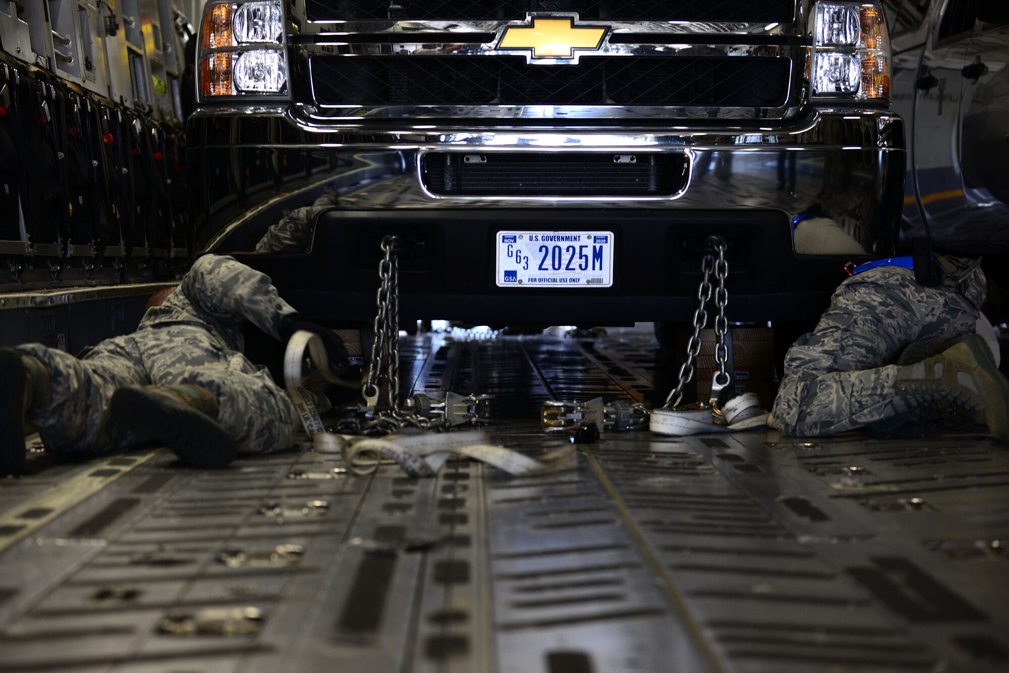 U.S. Air Force Airmen from the 633rd Logistics Readiness Squadron chain down a vehicle inside of a C-17 Globemaster III from Joint Base Charleston S.C., at Langley Air Force Base, Va., Aug. 27, 2015. The 633rd LRS members inspected and assisted in loading several vehicles during a deployment readiness exercise involving members of Joint Task Force-Civil Support, 633rd Air Base Wing and the 437th Airlift Wing.  (U.S. Air Force photo by Senior Airman Kimberly Nagle/Released)