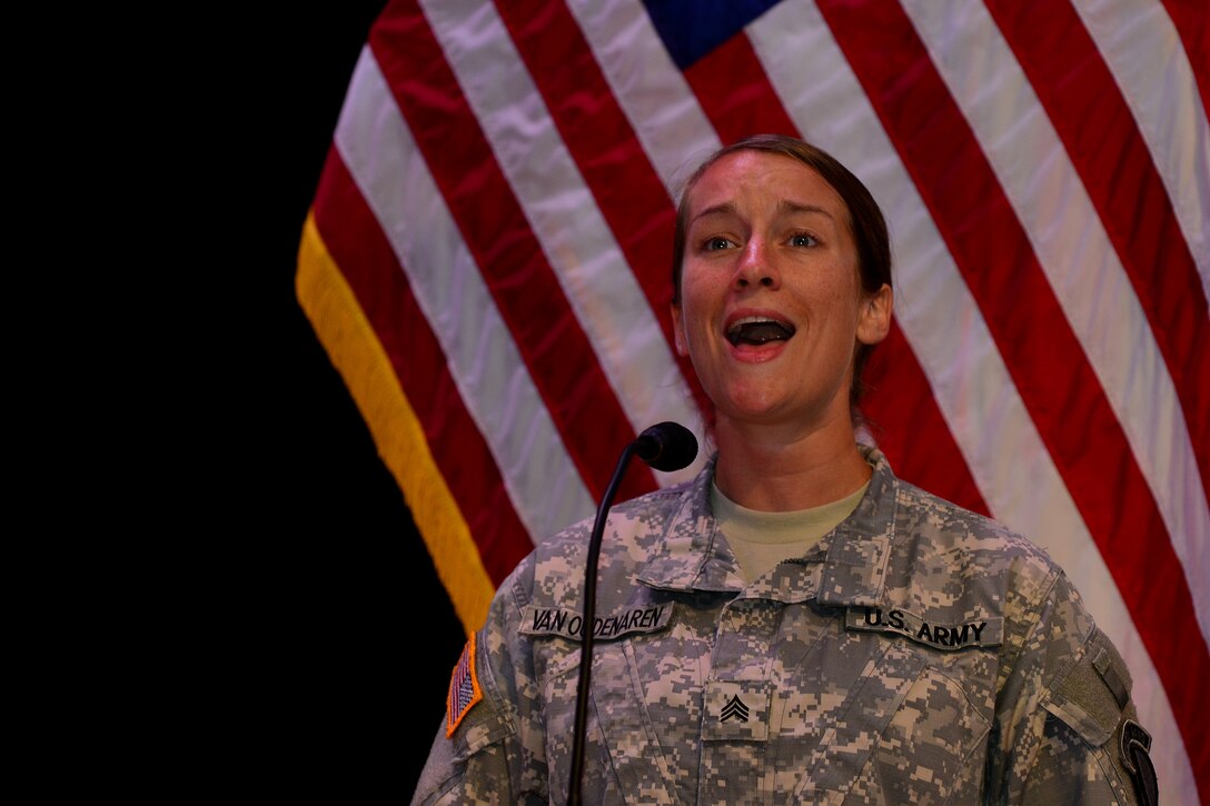 U.S. Army Sgt. Megan Van Oudenaren, U.S. Army Training and Doctrine Command Band vocalist, sings the national anthem during the Women’s Equality Observance event Aug. 26, 2015, at Fort Eustis, Va. The observance included a skit, historic overview of women’s equality and a speech from Thursa D. Crittenden, a Hampton Roads area community activist. (U.S. Air Force photo by Staff Sgt. Natasha Stannard/Released)