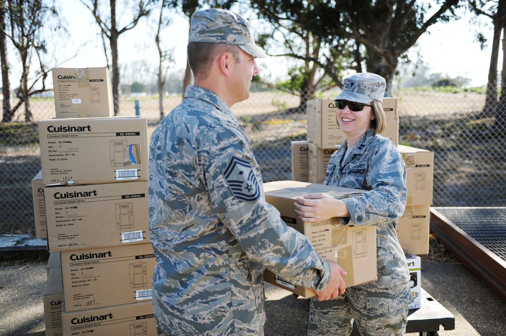 Capt. Krista Ingram, 30th Space Wing chaplain, hands a coffee maker to Senior Master Sgt. Zack Stys, 30th Civil Engineer Squadron first sergeant, during Operations Coffee Drop, Aug. 27, 2015, Vandenberg Air Force Base, Calif. The 30th SW chapel distributed 77 coffee makers to Team Vandenberg to improve morale and welfare. (U.S. Air Force photo by Staff Sgt. Jim Araos/Released)