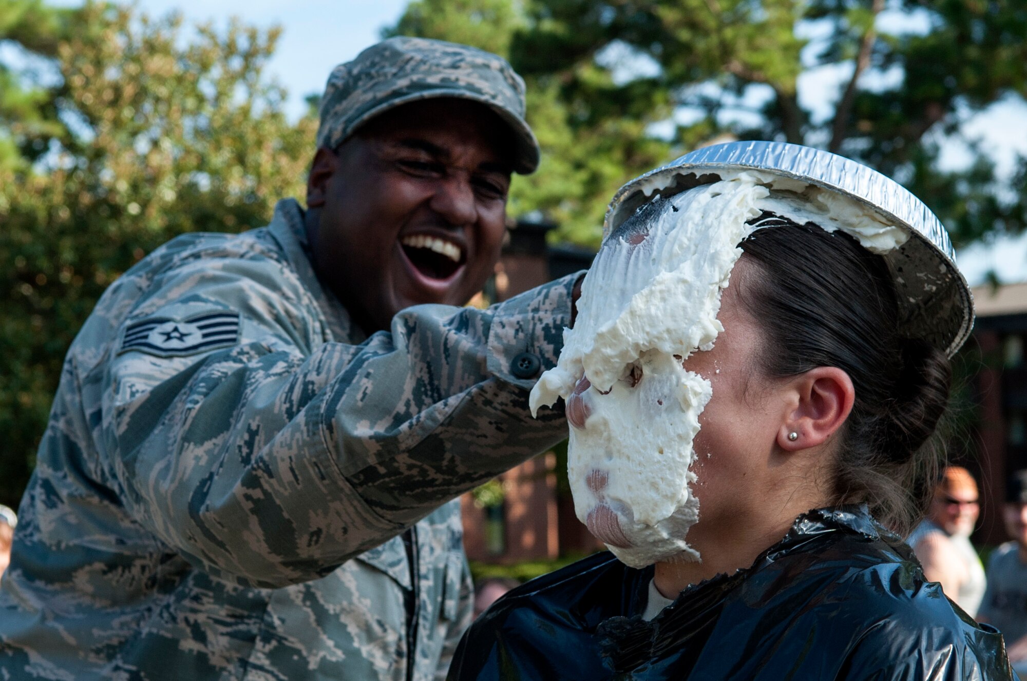 Staff Sgt. Virgil Bass (left), 4th Civil Engineer Squadron Airmen dormitory leader, laughs as he pies Staff Sgt. Alicia Peña, 4th CES ADL, during the Summer Music Fest, Aug. 29, 2015, at Seymour Johnson Air Force Base, North Carolina. Multiple pies were auctioned off during the event, with proceeds benefitting the Airmen’s Dorm Council. (U.S. Air Force photo/Airman 1st Class Shawna L. Keyes)