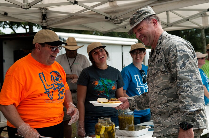Col. Mark Slocum (right), 4th Fighter Wing commander, laughs with local church volunteers during the Summer Music Fest, Aug. 29, 2015, at Seymour Johnson Air Force Base, North Carolina. More than 30 members from local churches came out to volunteer and interact with Airmen during the event. (U.S. Air Force photo/Airman 1st Class Shawna L. Keyes)