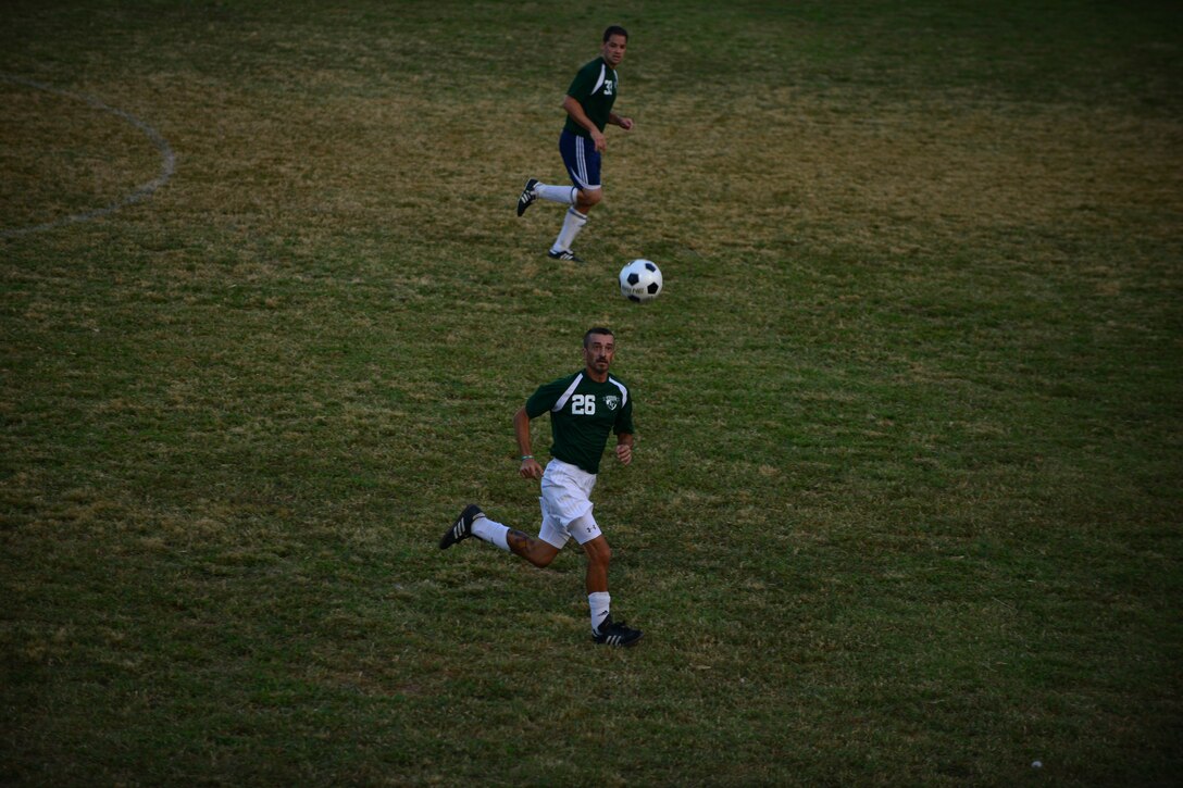 Langley All Star players Jose Gomez, right, and U.S. Air Force Maj. Javier Padial chase the ball during the Joint Base Langley-Eustis intramural soccer championship Aug. 26, 2015, at Fort Eustis, Va. The team’s scores stayed close throughout the game until going into overtime, during which the Langley All Stars scored two goals. (U.S. Air Force photo by Staff Sgt. Natasha Stannard/Released)