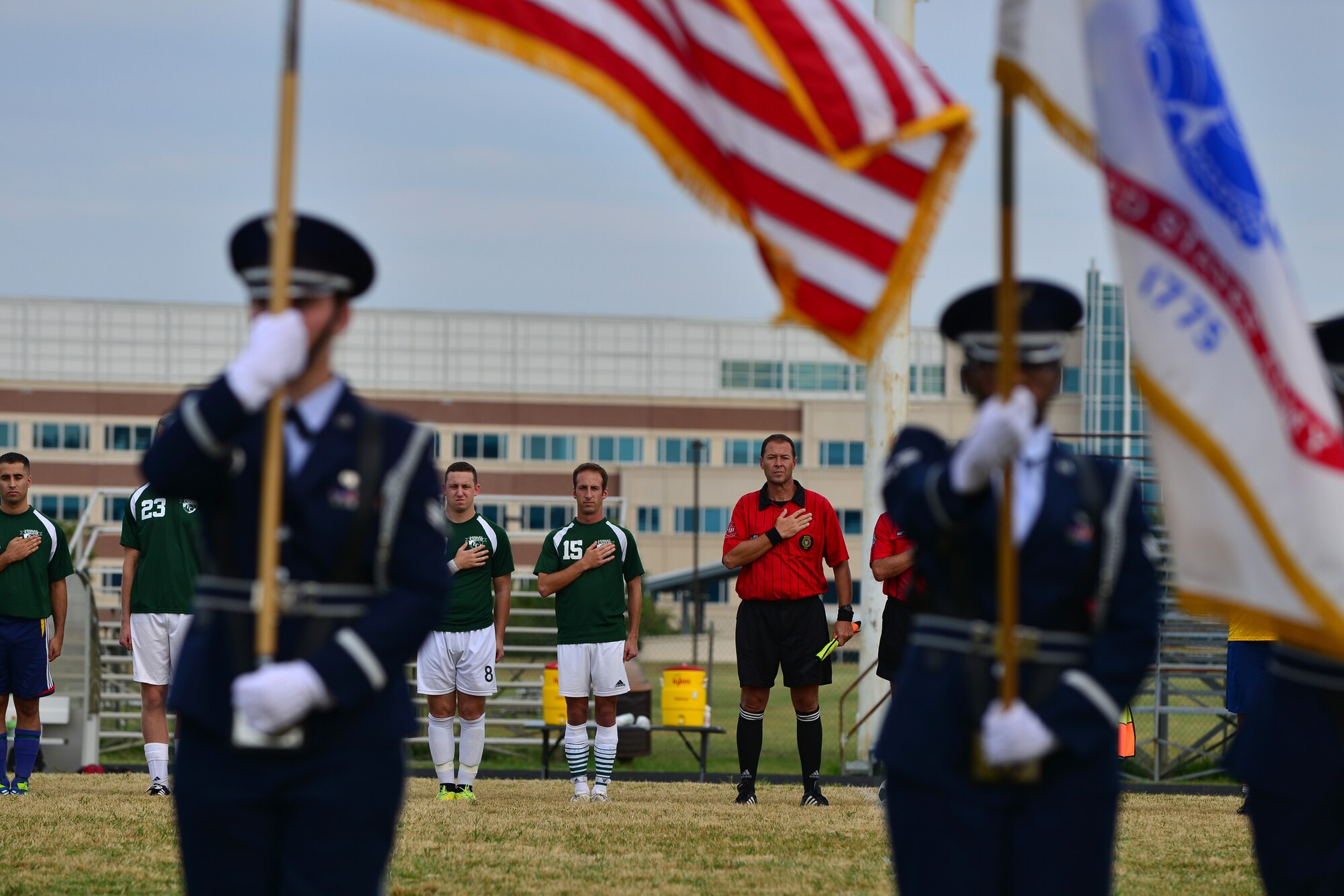 Players honor the U.S. flag during a rendition of the National Anthem before the Joint Base Langley-Eustis intramural soccer championship Aug. 26, 2015, at Fort Eustis, Va. The game marked the first JBLE sports championship between the top Fort Eustis and Langley Air Force Base players. (U.S. Air Force photo by Staff Sgt. Natasha Stannard/Released)