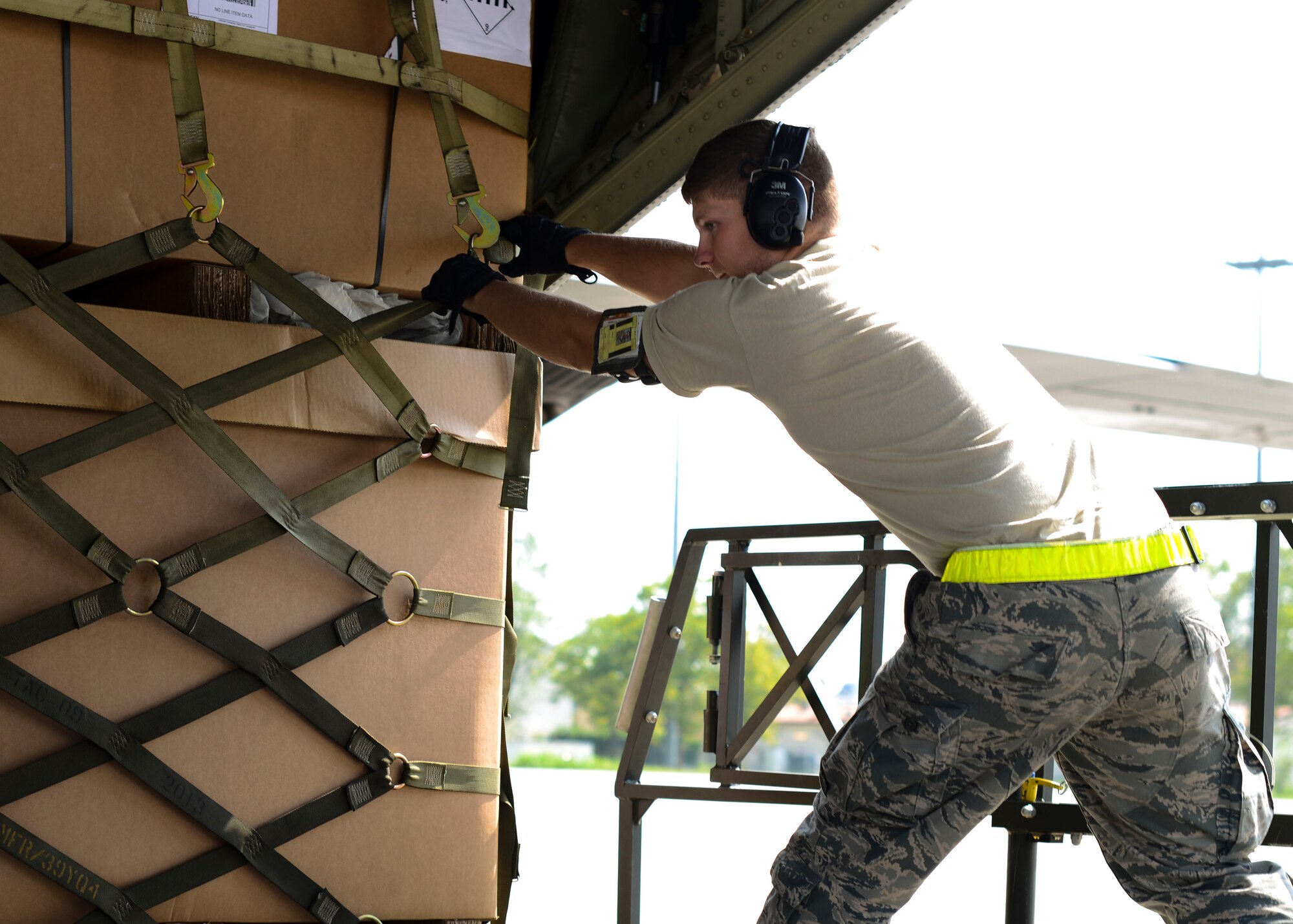 U.S. Air Force Airman 1st Class Joseph Coltson, 724th Air Mobility Squadron aircraft services specialist, pulls cargo from a C-130 Super Hercules onto a container transporter, Aug. 28, 2015, at Aviano Air Base, Italy. Airmen from the 724th AMS can immediately unload equipment on the flightline so the pallets can be returned to the cargo aircraft. (U.S. Air Force photo by Senior Airman Austin Harvill/Released)