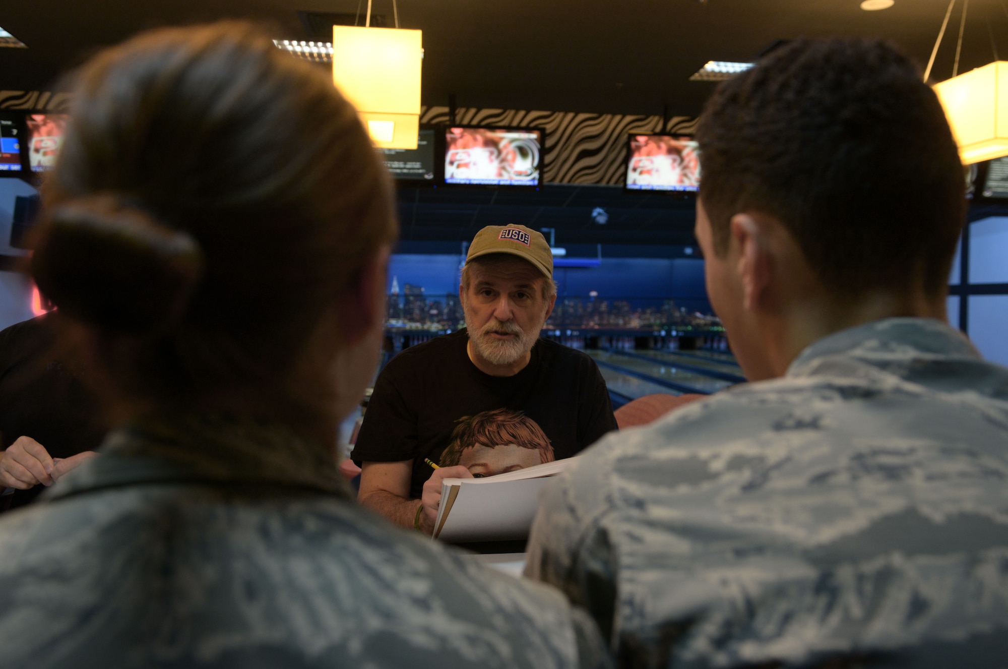 Sam Viviano, a National Cartoonist Society member on tour with the USO, draws caricatures of two Airmen during a USO-tour Aug. 27, 2015, at Incirlik Air Base, Turkey. Viviano, along with eight other cartoonists, drew caricatures and cartoons for Incirlik AB service members and their families during their two-day visit. (U.S. Air Force photo by Senior Airman Krystal Ardrey/Released)