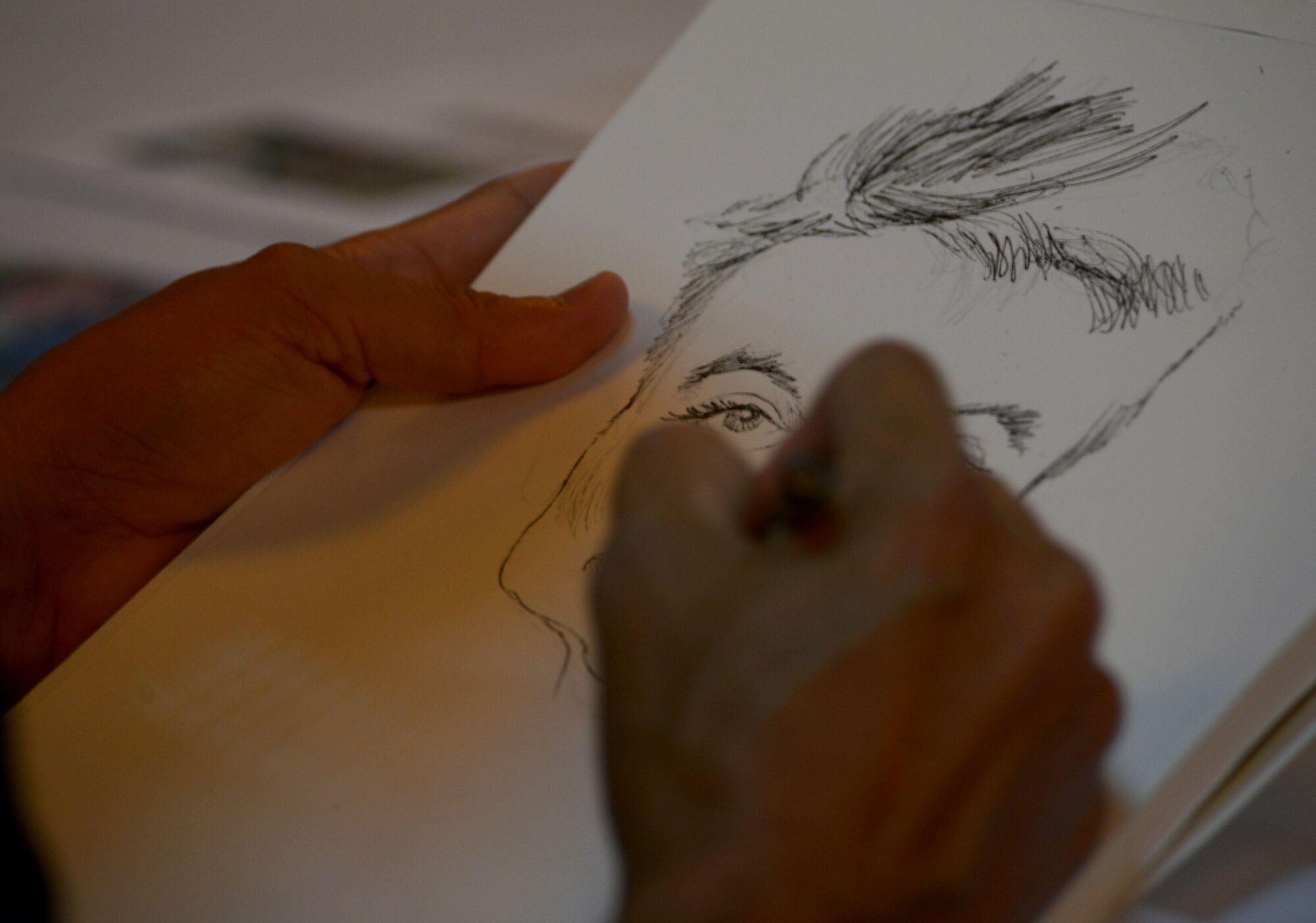 Mike Ramirez, a National Cartoonist Society member on tour with the USO, draws a caricature of a child Aug. 27, 2015, at Incirlik Air Base, Turkey. Ramirez toured with eight other cartoonists as part of a USO event and visited service members and their families at bases in Kuwait, Africa and Turkey. (U.S. Air Force photo by Senior Airman Krystal Ardrey/Released)