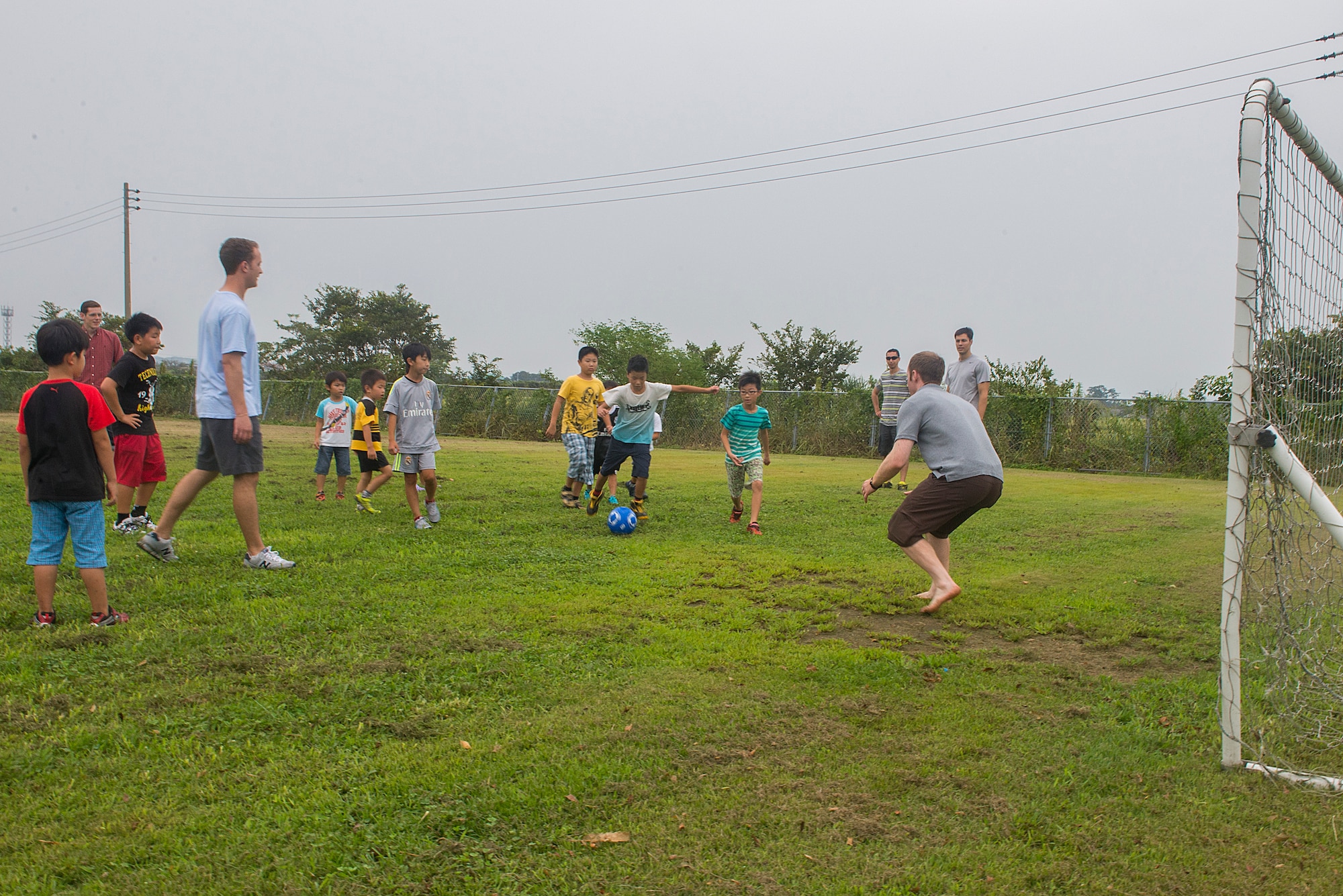 U.S. Air Force members from the 44th Fighter Squadron and 44th Aircraft Maintenance Unit play soccer with school age children at Chikujo Youth Center in Chikujo Town, Japan, Aug. 29, 2015. Members from the 18th Wing temporarily deployed to Tsuiki, Japan, to participate in Aviation Training Relocation from Kadena Air Base, Japan, to practice deployed operations and perform bilateral training in a joint environment alongside the Japan Air Self-defense Force’s 8th Air Wing. During the ATR, members also participated in numerous community outreach events as well as visited nearby schools and daycares in order to build ties with the local community. The groups played vollyball, soccer, basketball and several other games with students during their recess. (U.S. Air Force photo by Senior Airman Stephen G. Eigel)