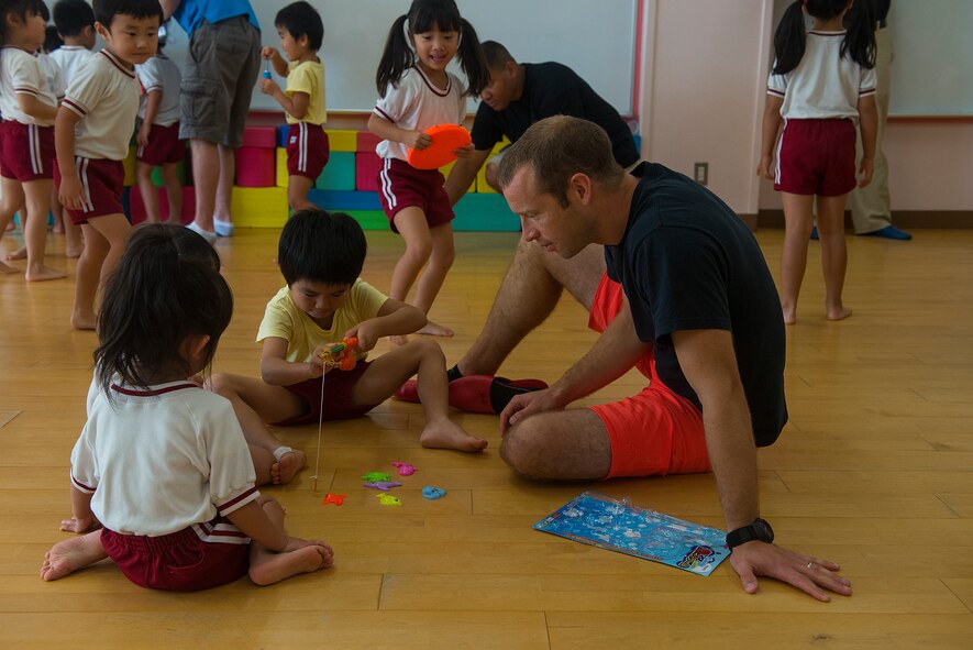 U.S. Air Force Lt. Col. Nick Register, 44th Fighter Squadron F-15 Eagle pilot, helps children at Toyotsu Day Care in Miyako town, Japan, while temporarily deployed for an Aviation Training Relocation Aug. 28, 2015. The 44th came to Tsuiki, Japan, to participate in a two-week ATR with Japan Air Self-Defense Force F-15J pilots to improve bilateral interoperability between the two nations. During the deployment, however, the Airmen have also visited three local schools and a daycare before participating in a parade with the local community. (U.S. Air Force photo by Senior Airman Stephen G. Eigel)
