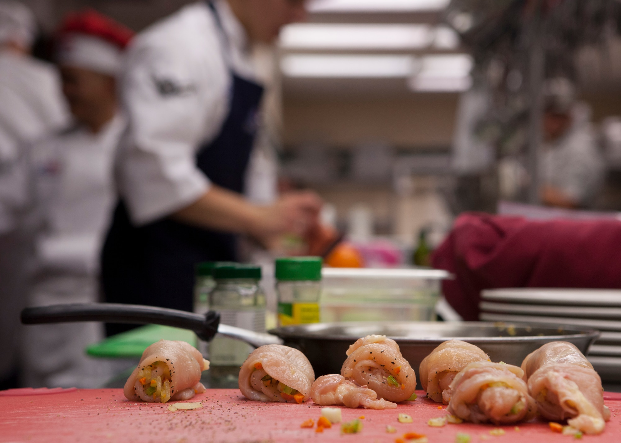 Chefs from 90th Force Support Squadron work in a cramped kitchen during an “Iron Chef”-style competition at the Chadwell Dining Facility on F.E. Warren Air Force Base, Wyo., Aug. 27, 2015. The winning recipe was a peanut butter cracker crusted chicken roulade with herb cream sauce. (U.S. Air Force photo by Lan Kim)