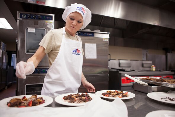 Staff Sgt. Shasta Ward, 90th Force Support Squadron missile feeding non-commissioned officer in charge, sprinkles the finishing touches on a dessert dish during an Iron Chef competition held at the Chadwell Dining Facility on F.E. Warren Air Force Base, Aug. 27, 2015. Ward and her teammates won the competition. (U.S. Air Force photo by Lan Kim)