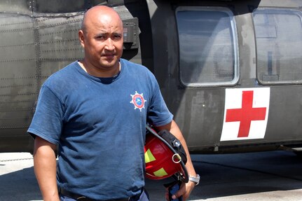 SOTO CANO AIR BASE, Honduras - Miguel Matus, a firefighter with the Belize National Fire Service, poses for a photo next to a Blackhawk UH-60 helicopter after practicing loading and unloading patients Aug. 27, 2015,during CENTAM SMOKE, a quarterly firefighting exercise hosted by Joint Task Force-Bravo at Soto Cano Air Base, Honduras. CENTAM SMOKE allows firefighters from Central America to train with U.S. firefighters in structural fires, aircraft fires, emergency evacuation and vehicle extractions to build partnership and improve interoperability. (U.S. Army photo by Maria Pinel) 
 
