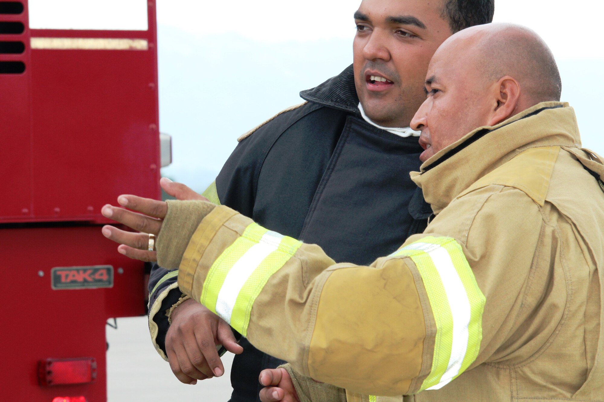 SOTO CANO AIR BASE, Honduras - SOTO CANO AIR BASE, Honduras - Miguel Matus, a firefighter from the Belize National Fire Service (front), and Edgar Peña, a firefighter from the Honduran Fire Department (back), plan their response to an aircraft fire scenario Aug. 26, 2015during CENTAM SMOKE, a quarterly firefighting exercise hosted by Joint Task Force-Bravo at Soto Cano Air Base, Honduras. CENTAM SMOKE allows firefighters from Central America to train with U.S. firefighters in structural fires, aircraft fires, emergency evacuation and vehicle extractions to build partnership and improve interoperability. (U.S. Army photo by Maria Pinel) 