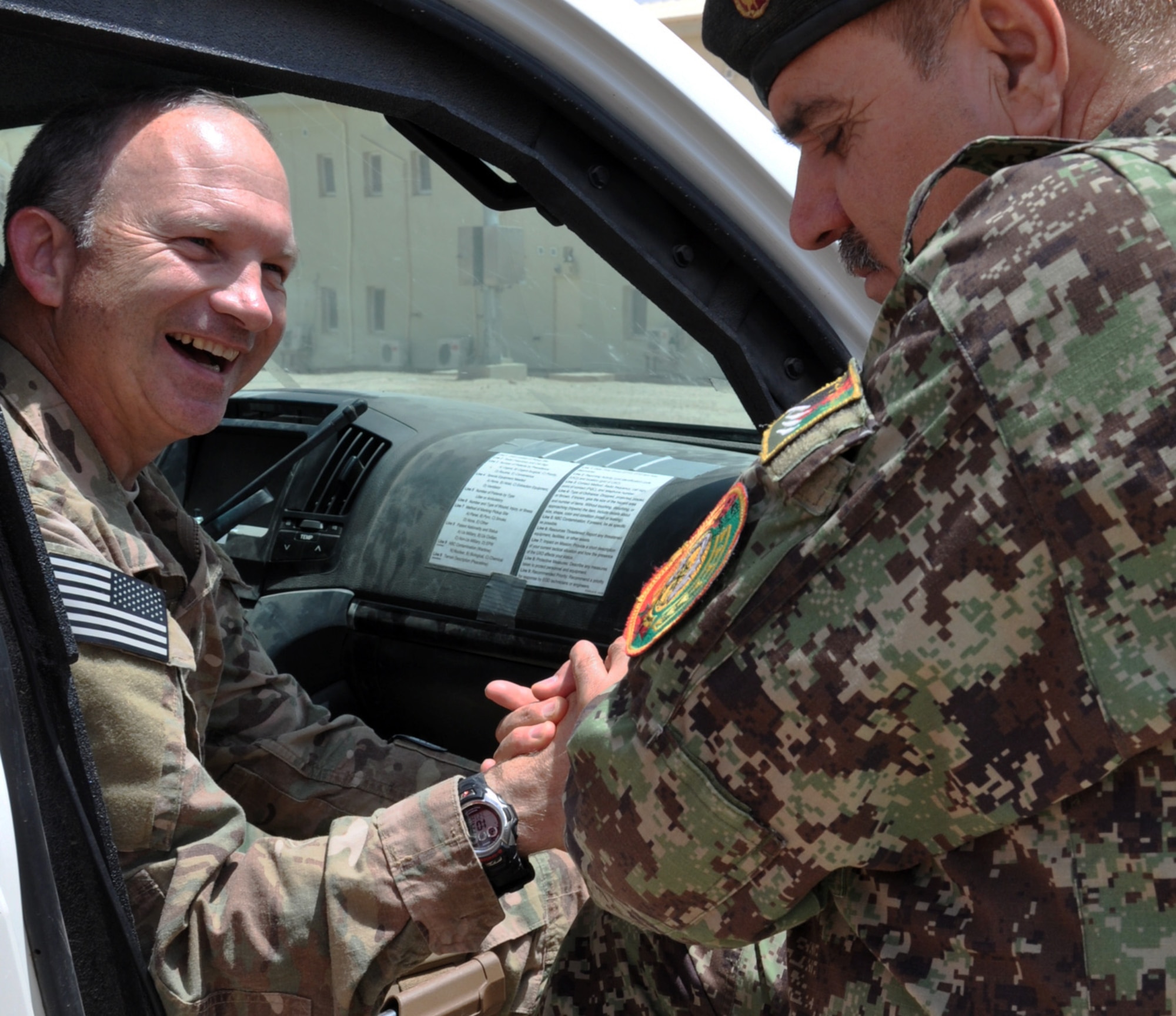 Helmand, Afghanistan (July 25, 2015) - U.S. Air Force Col. Donald Holloway, Resolute Support Advise and Assist Cell-Southwest team lead and ANA 215th Corps G3, Operations Officer Col. Aslum enjoy a moment camaraderie after initial meetings earlier in the day.