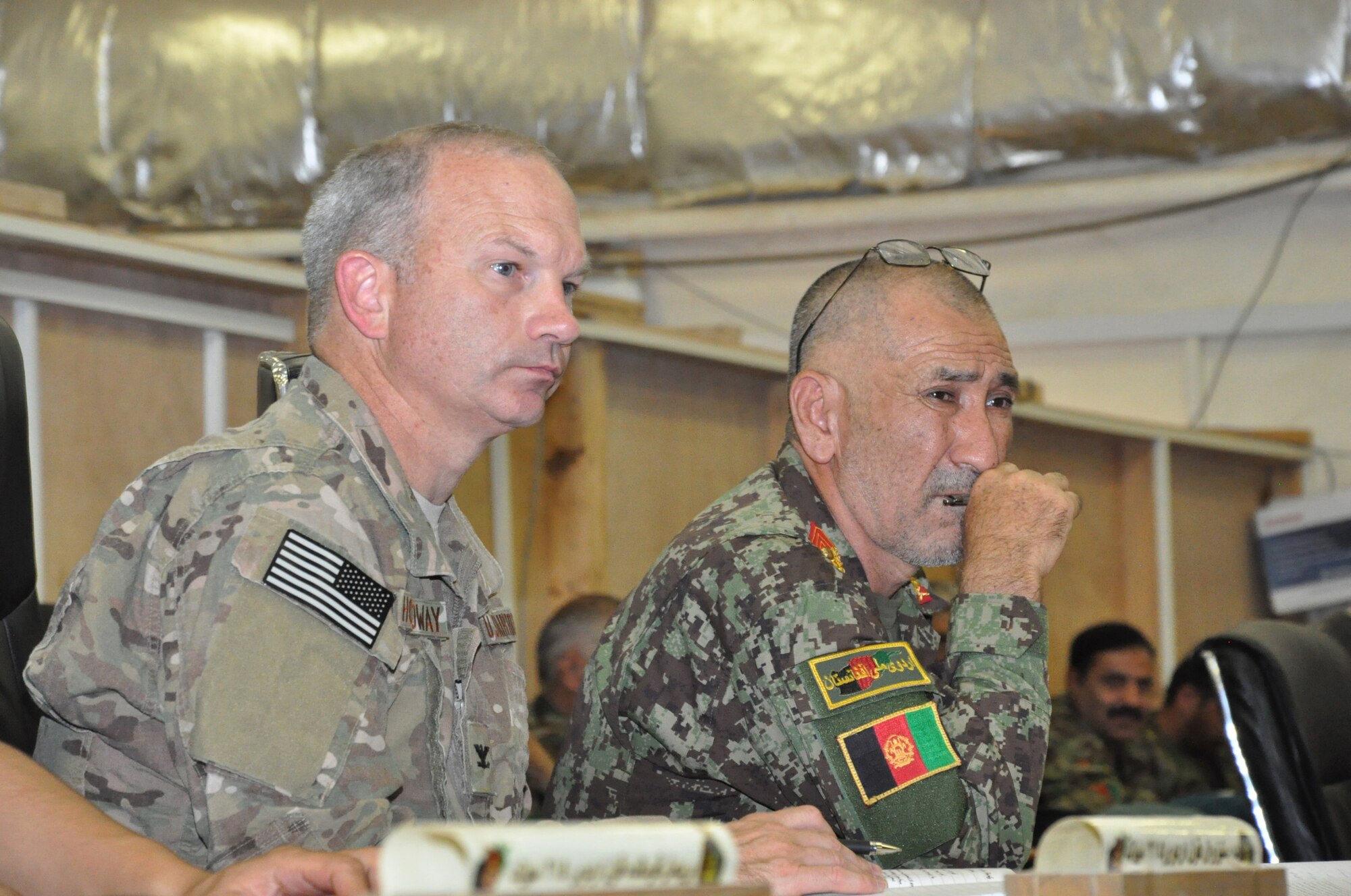 Helmand, Afghanistan (July 25, 2015) - U.S. Air Force Col. Donald Holloway, Resolute Support Advise and Assist Cell-Southwest team lead and ANA 215th Corps Executive Officer, Afghan Brig. General Zamin Hassan listen to the 215th Corps battle update brief for the day.