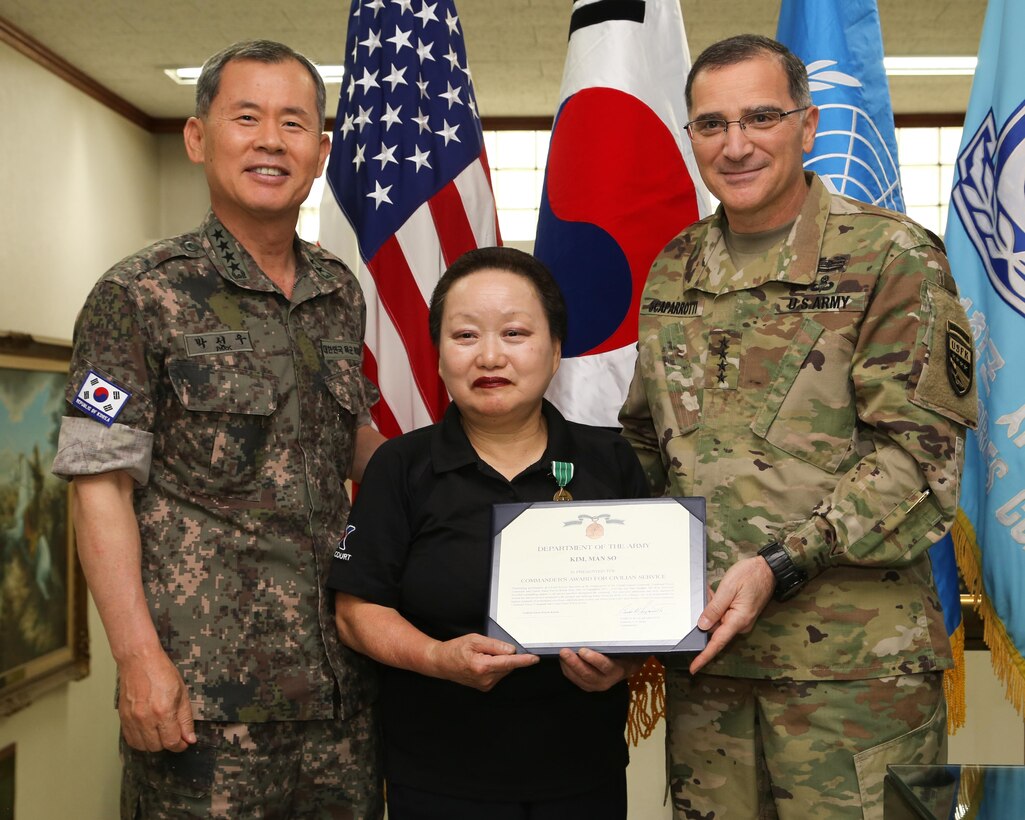YONGSAN GARRISON, Seoul, Republic of Korea - Gen. Curtis M. Scaparrotti, United Nations Command, Combined Forces Command, U.S. Forces Korea commander and Gen. Park, Sun-Woo, deputy commander of Combined Forces Command, present Ms. Kim Man-so, an Army and Air Force Exchange Services employee with the Commanders Award for Civilian Service September 2 at the UNC/CFC/USFK Headquarters Building here. Ms. Kim has faithfully served the service members, civilians and other members of the ROK - U.S. Alliance for more than 50 years. Katchi Kapshida!