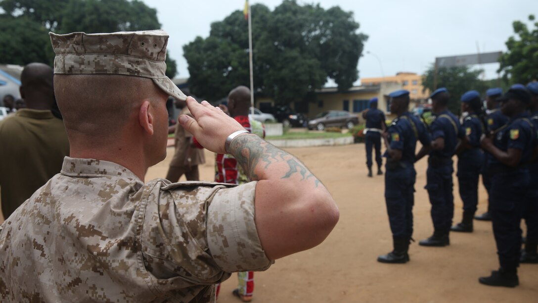 U.S. Marines and sailors, with Special-Purpose Marine Air-Ground Task Force Crisis Response-Africa Detachment A, salute during the Benin national anthem during the opening ceremony Aug. 31, 2015 that officially started training with Benin's National Surveillance Police at Benin's National Police Academy in Cotonou, Benin. Today’s ceremony marks a new milestone of the partnership between Benin and the U.S. This training is the first time in the Nation Surveillance Police’s 10-year history a foreign military has come to train and mentor the specialized unit. Benin's Minister of Interior Placide Azande and U.S. Embassy Benin Chargé d'affaires Todd Whatley were on hand for the ceremony. 