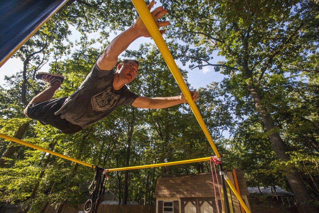 New Jersey Air National Guard Tech. Sgt. Justin B. Gielski swings on a set of bars he built in the backyard of his home in Medford, N.J., as he trains to compete on the TV show “American Ninja Warrior” Aug. 21, 2015. New Jersey Air National Guard photo by Master Sgt. Mark C. Olsen