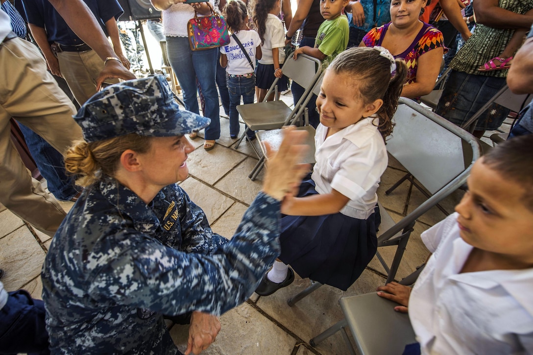 U.S. Navy Capt. Christine Sears, commanding officer of the Medical Treatment Facility on the Military Sealift Command hospital ship USNS Comfort, gives a high-five to a Honduran child during a ceremony to support Continuing Promise 2015 in Trujillo, Honduras, Aug. 29, 2015. The deployment conducts civil-military operations to show U.S. support and commitment to Central and South America and the Caribbean. U.S. Navy photo by Petty Officer 3rd Class Andrew Schneider