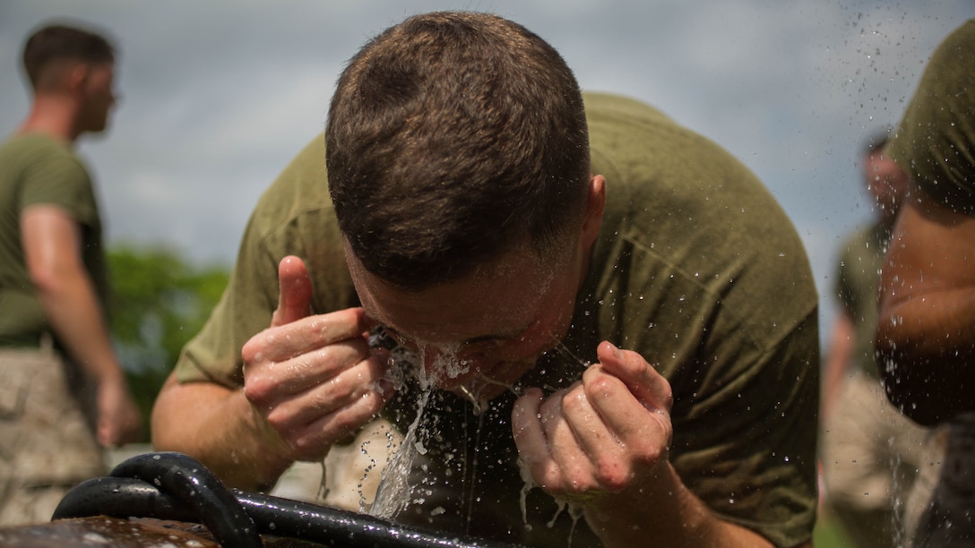 Marine Cpl. David B. Gale washes his face after completing the OC Spray Performance Evaluation Course on Camp Hansen, Okinawa, Japan, Aug. 27, 2015. Marines, Soldiers, Sailors and Airmen from across Okinawa participated in the Non-Lethal Weapons Instructor Course, which is only offered once a year to the service members on island. Gale from Kennewick, Washington, is a chemical, biological, radiological and nuclear defense specialist, with Headquarters Battalion, 3rd Marine Division, III Marine Expeditionary Force, and will have the collateral duty of non-lethal weapons instructor upon completion of the course. 