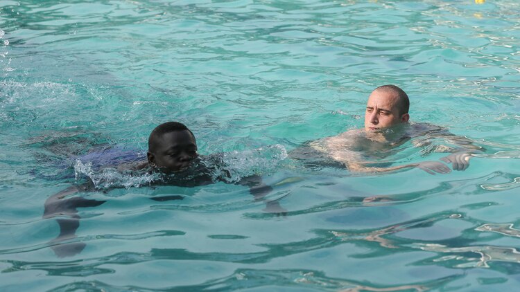 Cpl. Matt Sprankle, a Marine Corps Instructor of Water Survival with Special-Purpose Marine Air-Ground Task Force Crisis Response-Africa Detachment A, swims alongside a Compagnie Fusilier de Marin Commando during a swim assessment in Dakar, Senegal, August 27, 2015. The assessment was conducted to ensure the COFUMACO are capable and confident in the water before they conduct small-boat operations training together in the following weeks. 