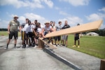 Members of the University of Missouri football team navigate a low-course challenge during a team-building event June 27, 2015, hosted by the Missouri Army National Guard Recruiting and Retention Battalion at Camp Clark in Nevada, Missouri. The team was given two wooden planks and two wooden pedestals to get everyone, including the planks, across from one pedestal to the other without touching the ground.